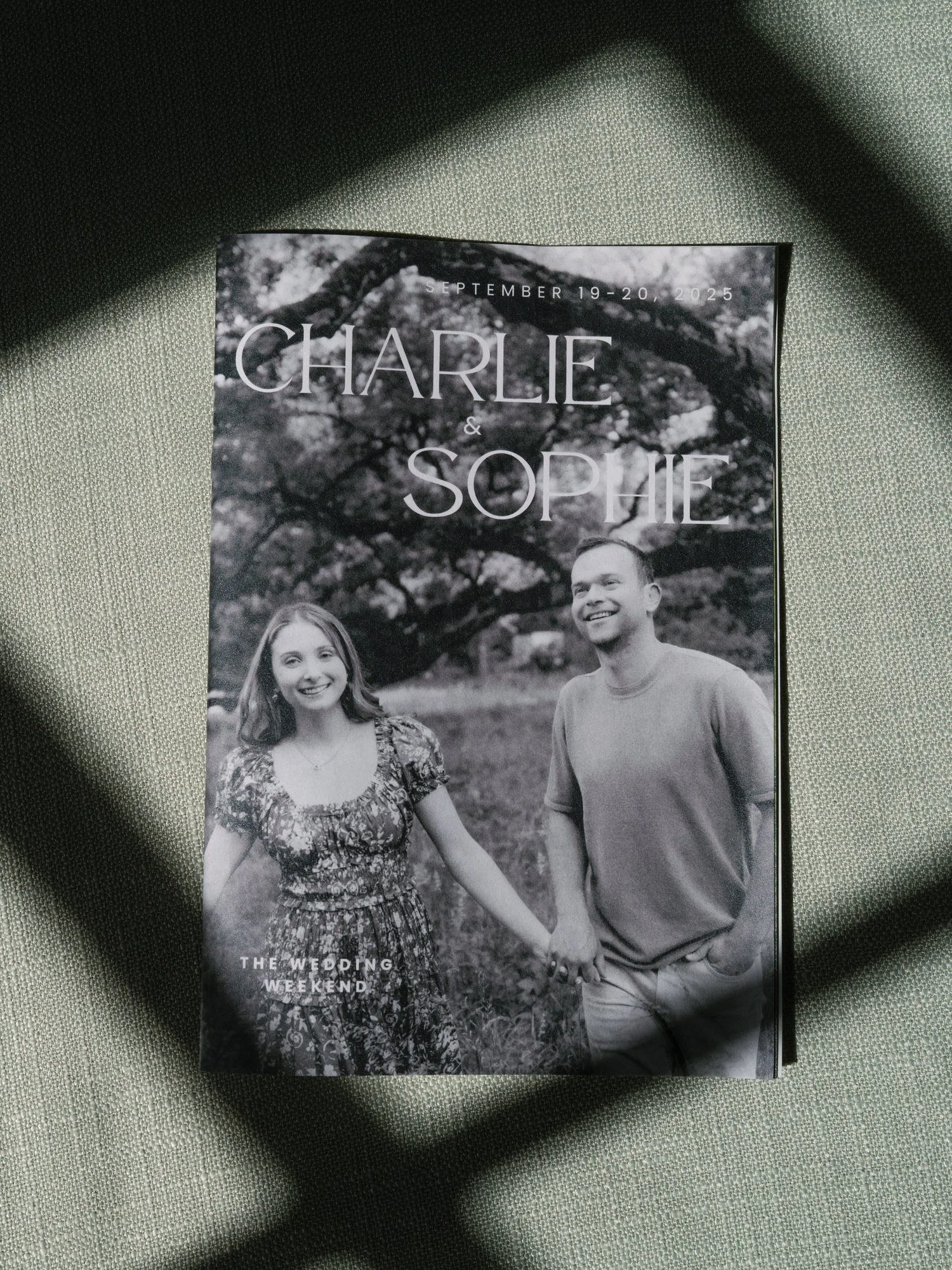 Black and white wedding weekend program featuring Charlie and Sophie on textured fabric at Troutbeck in Amenia, photographed by Jenny Fu.