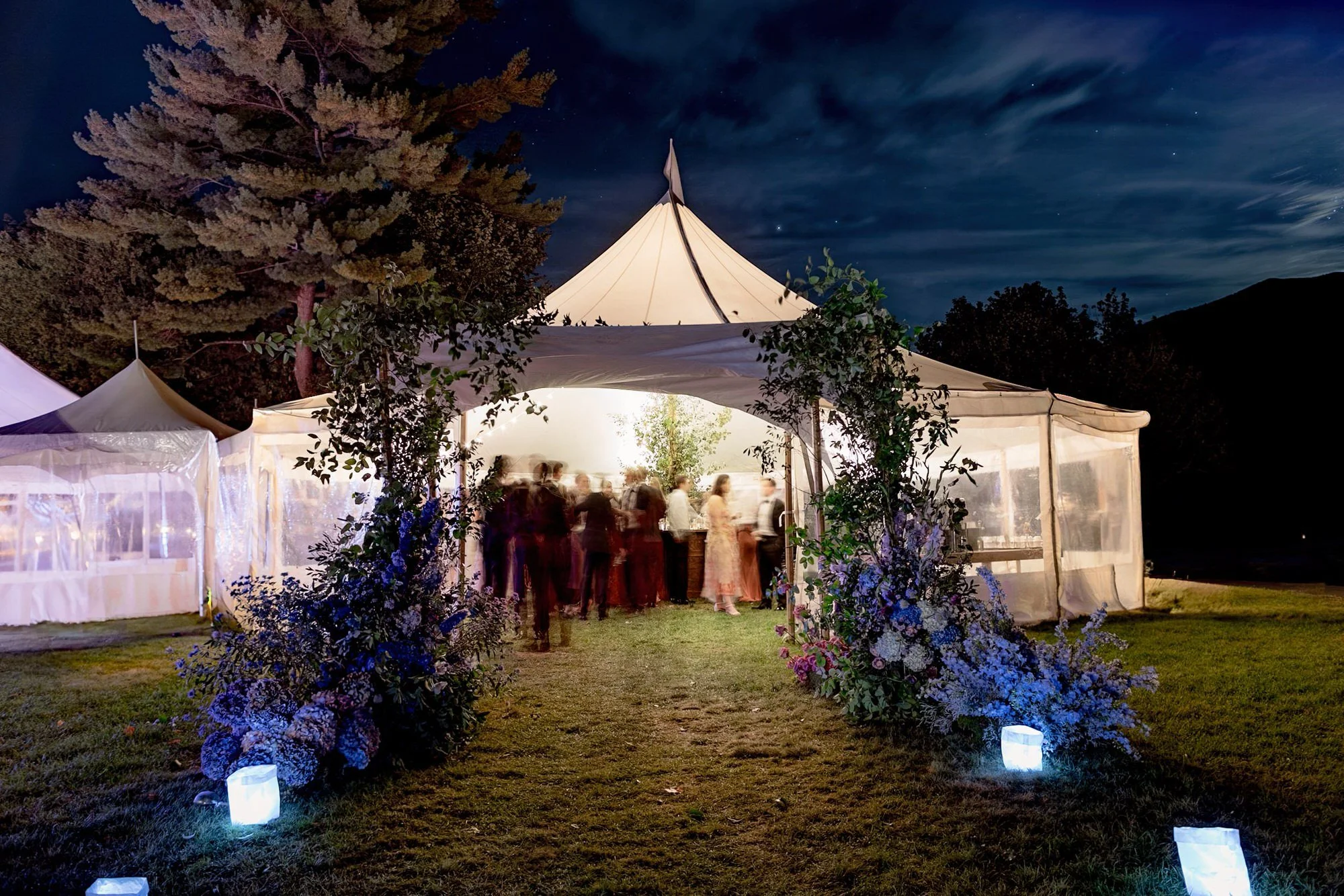 Nighttime wedding reception tent glowing under the stars at The Ausable Club in the Adirondack Mountains photographed by Jenny Fu