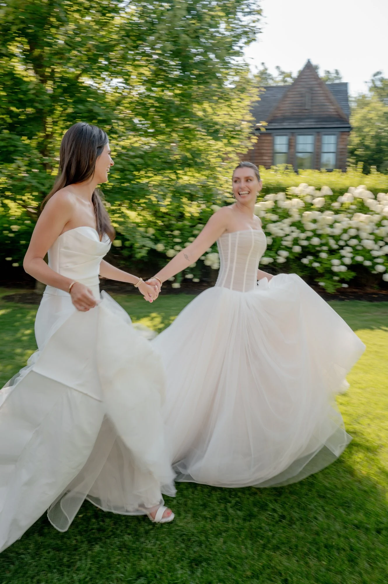 Brides running hand in hand across the garden at Valley Rock Inn in Sloatsburg, photographed by Jenny Fu.