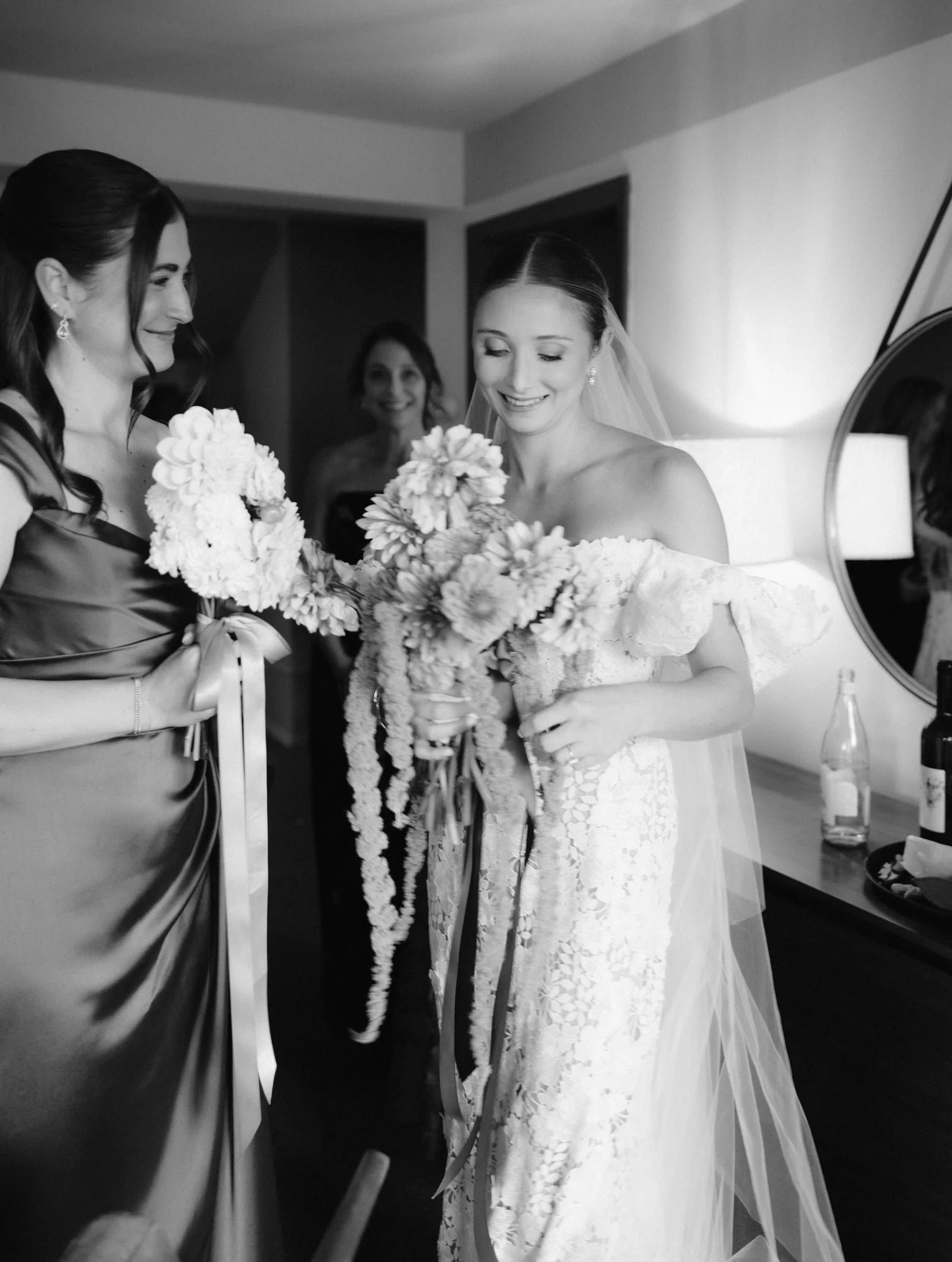 Bride smiling while holding her bouquet beside a bridesmaid just before the ceremony at Troutbeck in Amenia, photographed by Jenny Fu.