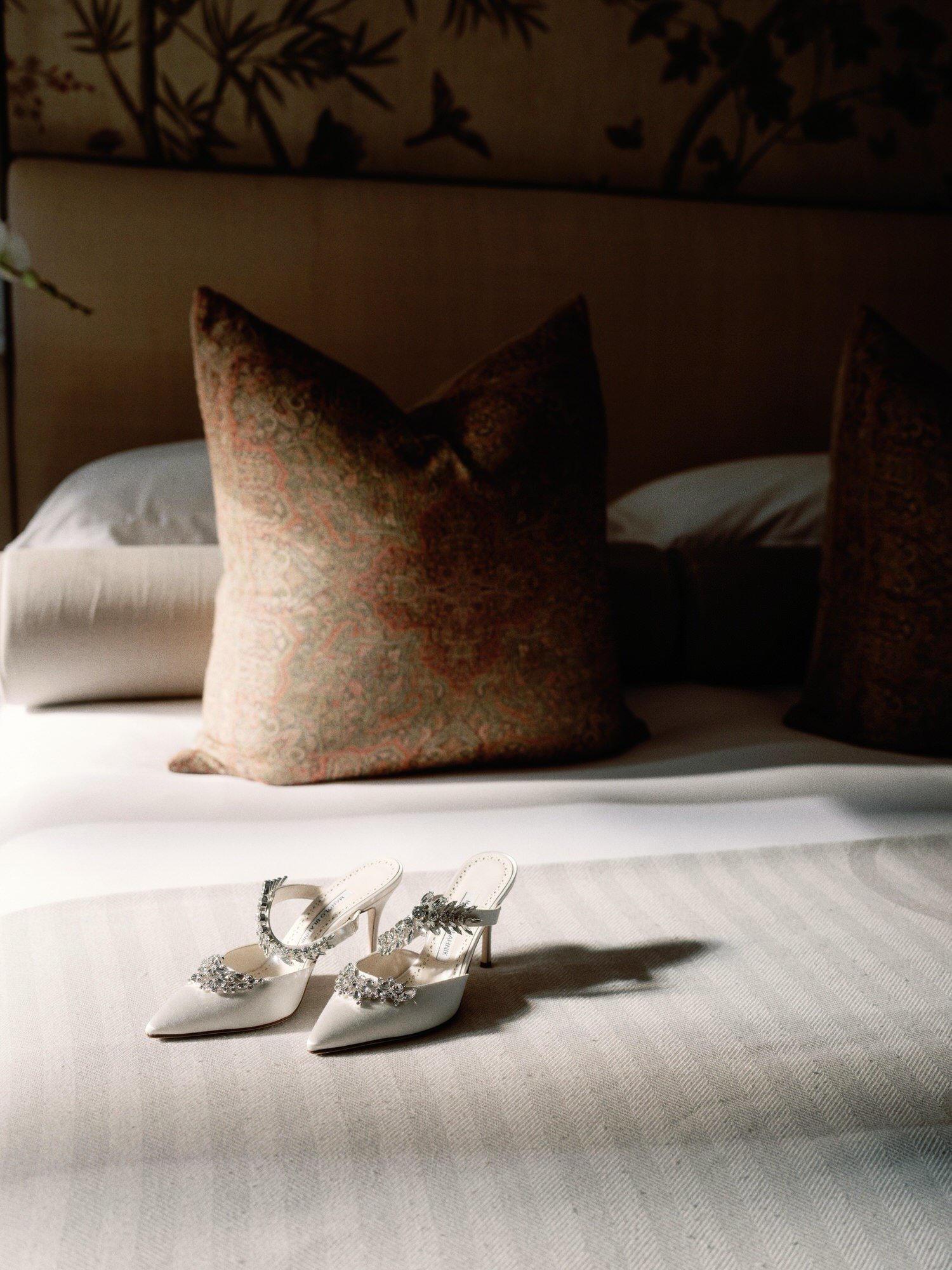ABJ-046-bridal-shoes-on-bed-with-patterned-pillows-the-lowell-hotel-nyc-jenny-fu.jpg