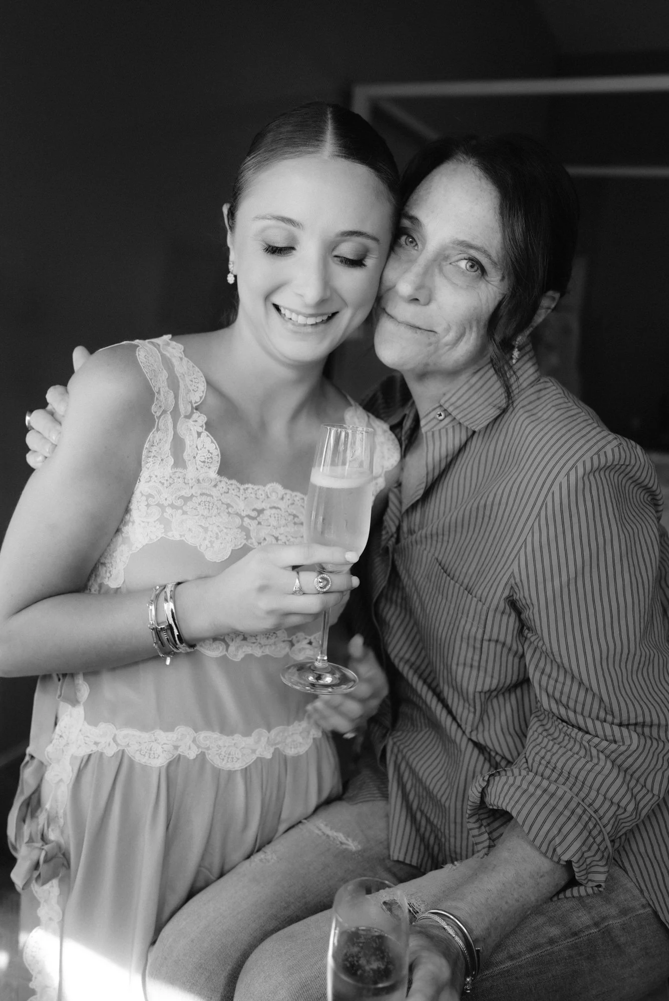 Tender moment of the bride sharing a champagne toast with her mother while getting ready at Troutbeck in Amenia, photographed by Jenny Fu.