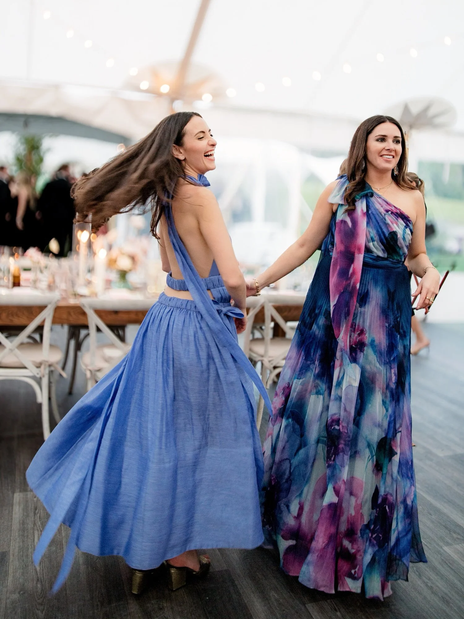Wedding guest in blue satin dress dancing and smiling with bride at Ausable Club reception