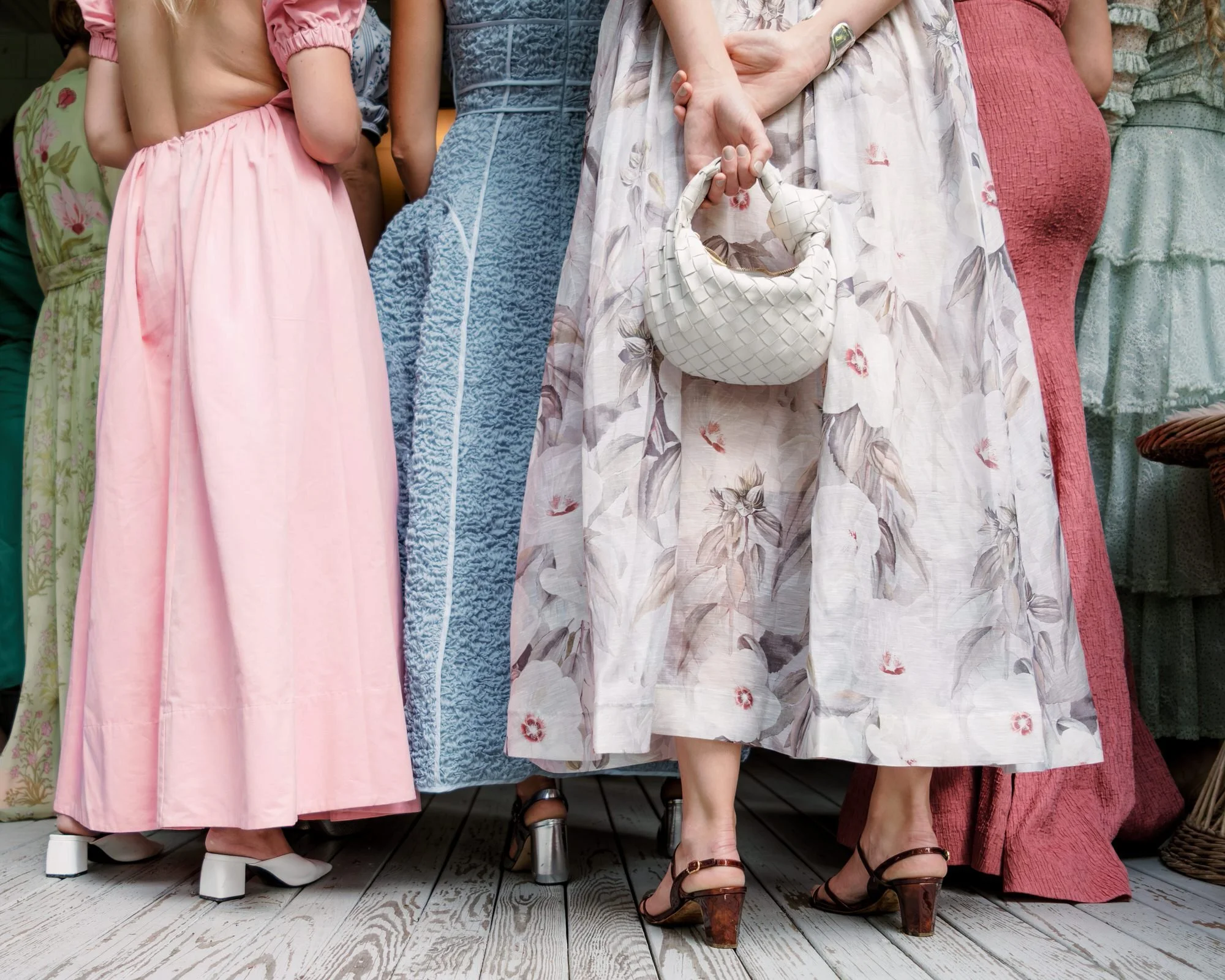 Wedding guests in colorful textured dresses standing together at The Ausable Club in the Adirondacks