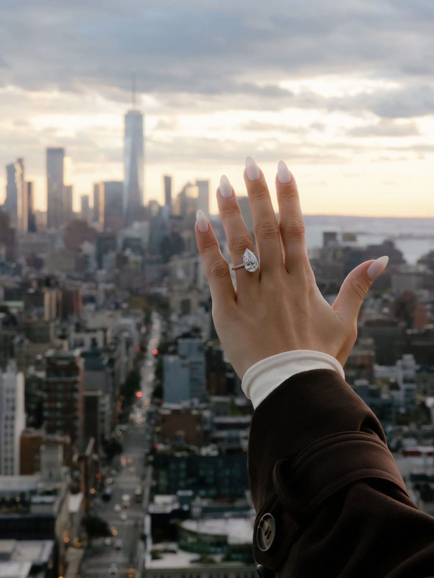 kj40-engagement-ring-hand-raised-over-nyc-skyline-rooftop-jenny-fu.jpg