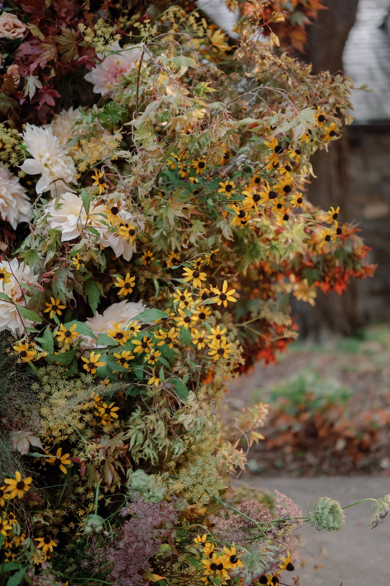 Detail of the ceremony floral installation with yellow blooms and autumn textures at Blue Hill at Stone Barns, photographed by Jenny Fu.