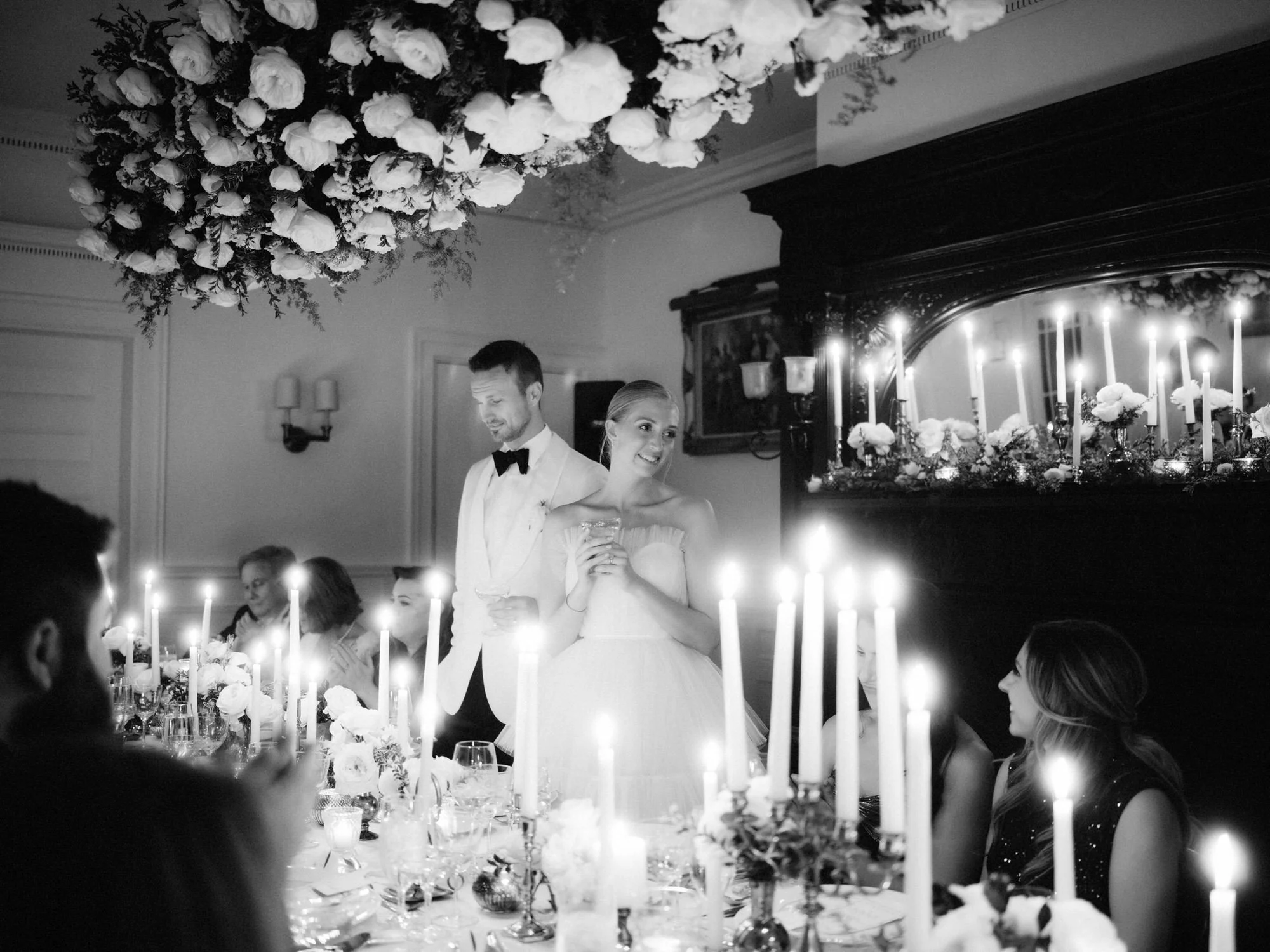 Bride and groom give a toast surrounded by candlelight and florals at their wedding dinner reception in the Berkshires, photographed by Jenny Fu.