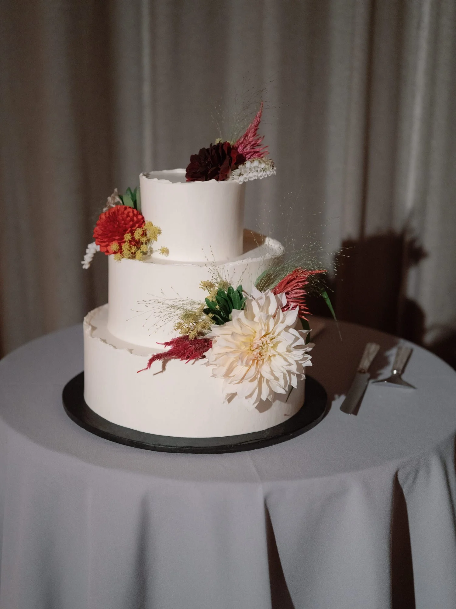 Three-tier buttercream wedding cake adorned with garden florals at Blue Hill at Stone Barns, photographed by Jenny Fu.