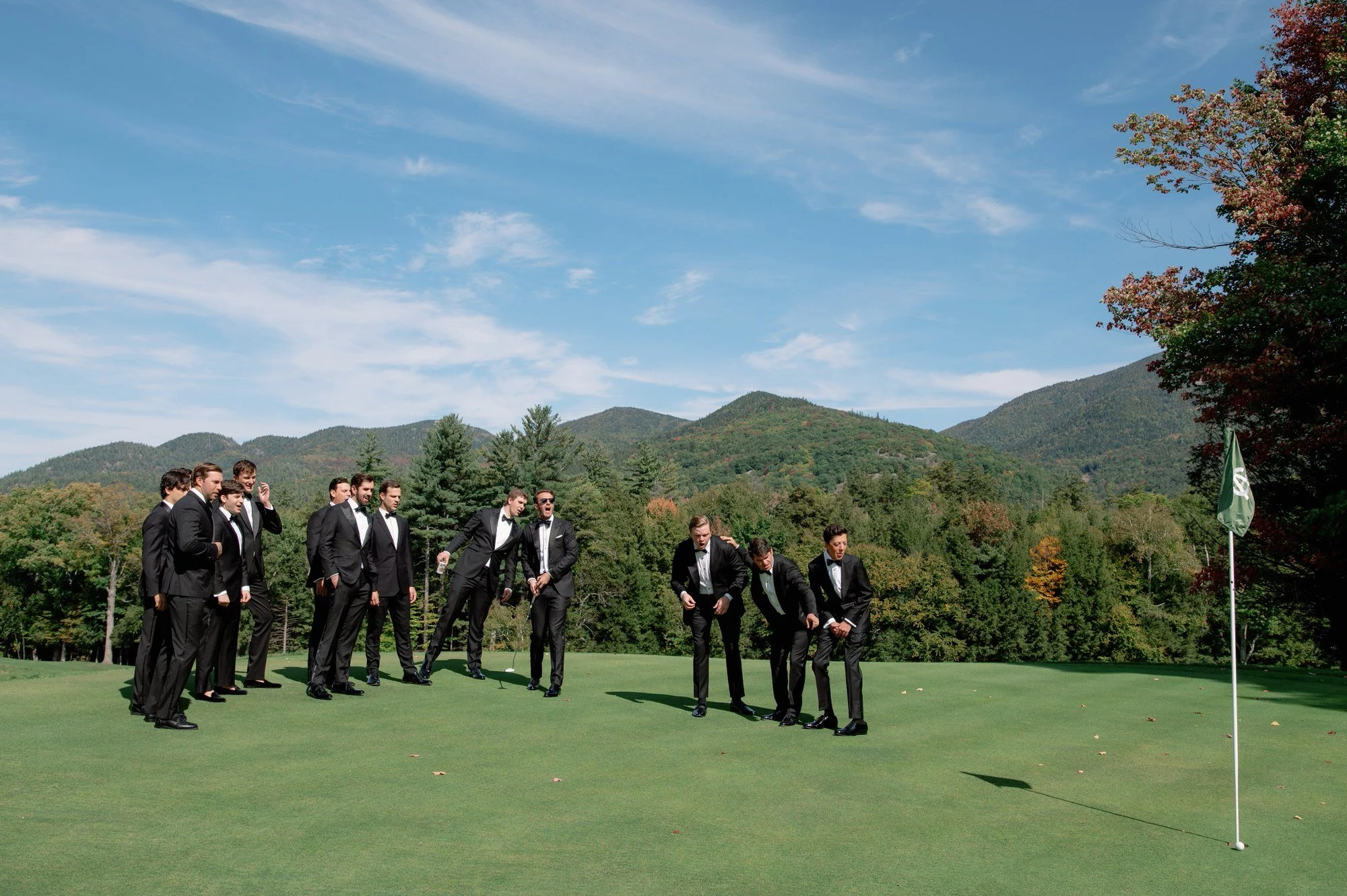 Groomsmen sharing a fun moment on the golf course during Olivia and Jack’s wedding at the Ausable Club in the Adirondacks