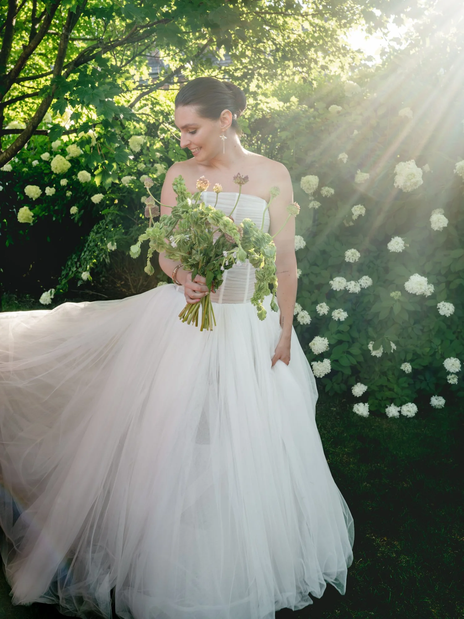 Bride framed by her veil holding a green bouquet as soft sunlight falls across her face at Valley Rock Inn in Sloatsburg, photographed by Jenny Fu.