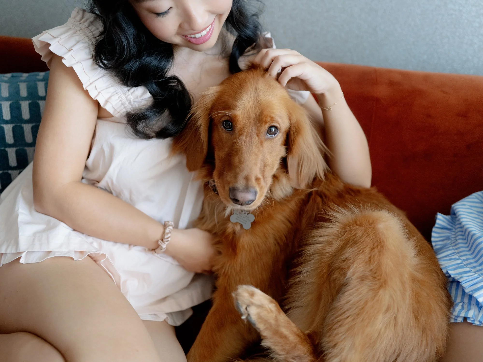 Bride relaxing on a sofa while cuddling her golden retriever in the morning, at Blue Hill at Stone Barns, photographed by Jenny Fu.