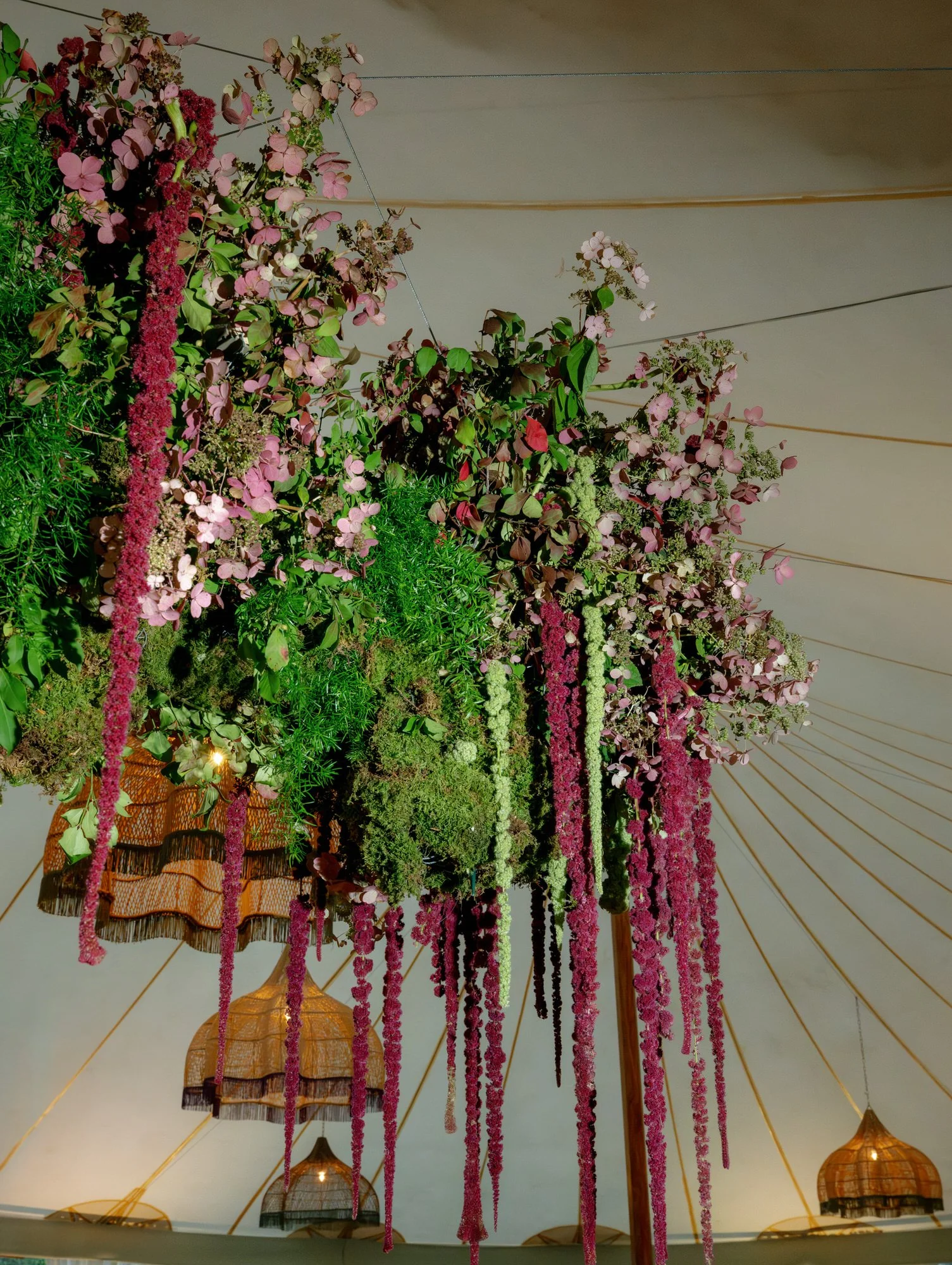Lush hanging floral chandelier with cascading amaranthus under the tent at Troutbeck in Amenia, New York, photographed by Jenny Fu.