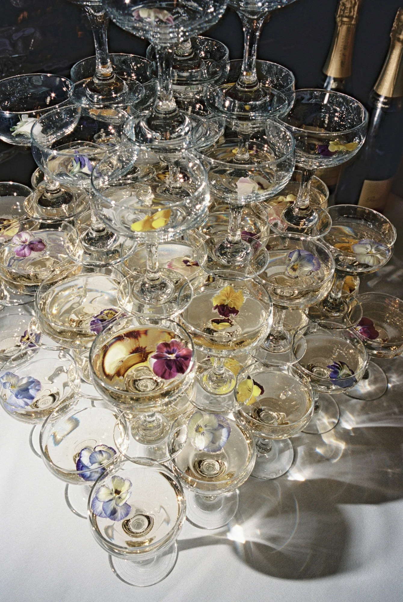Elegant champagne tower with coupe glasses garnished with edible flowers at Valley Rock Inn in Montvale, New Jersey, photographed by Jenny Fu.