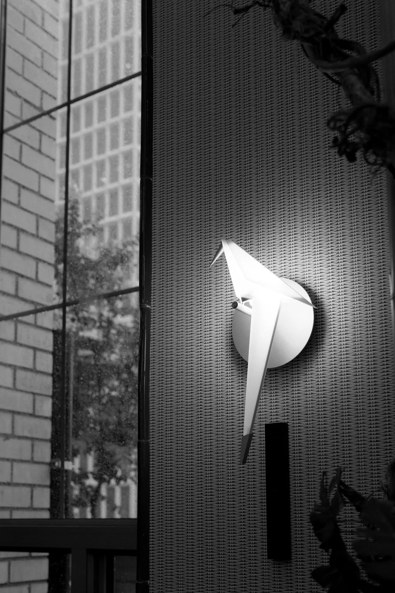 Black and white detail of a white bird sculpture mounted on a textured wall, from a Waldorf Astoria New York wedding photographed by Jenny Fu.