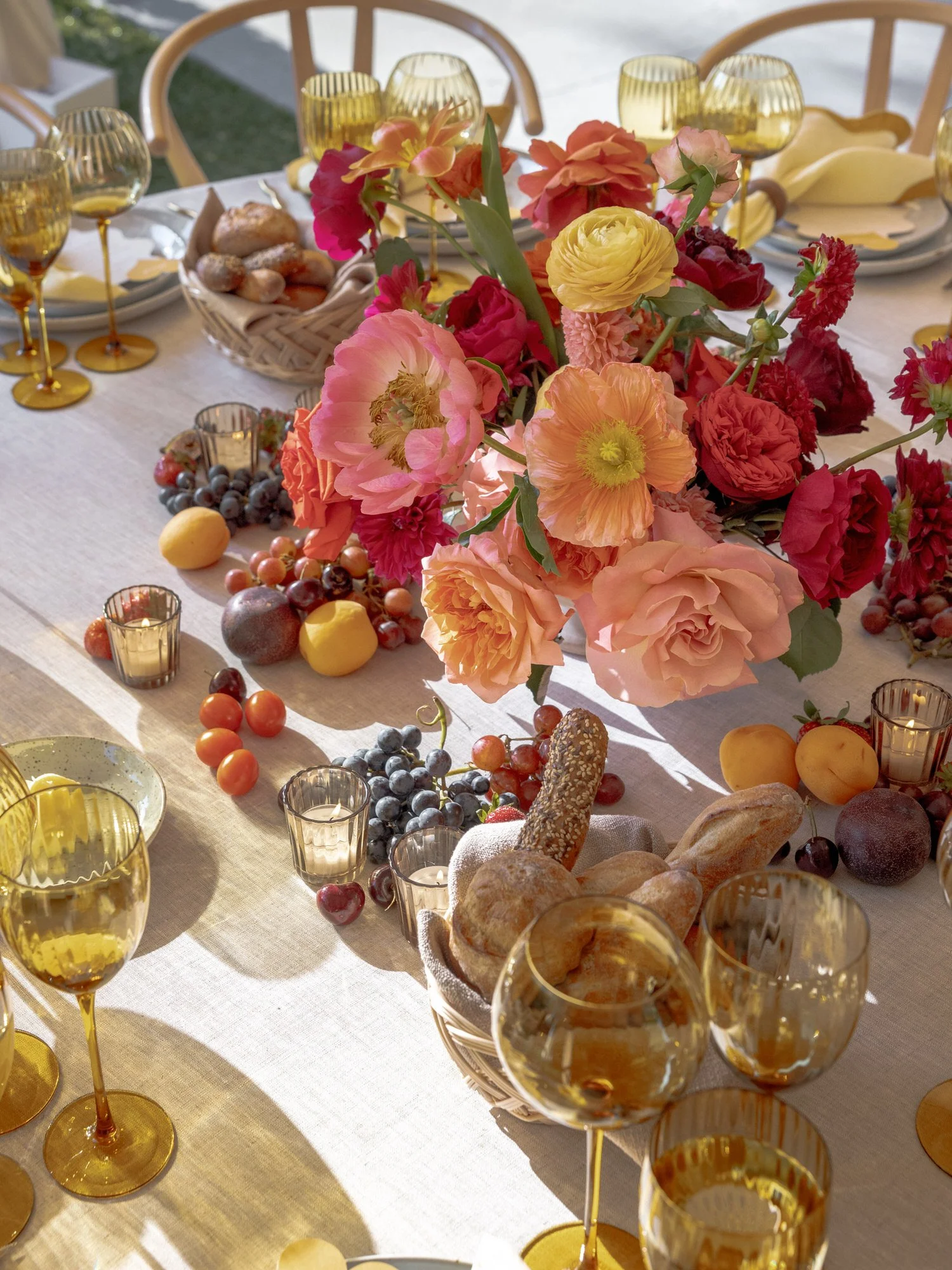Citrus-toned florals surrounded by fresh fruit and bread create a lush tablescape at Valley Rock Inn in Sloatsburg, photographed by Jenny Fu.