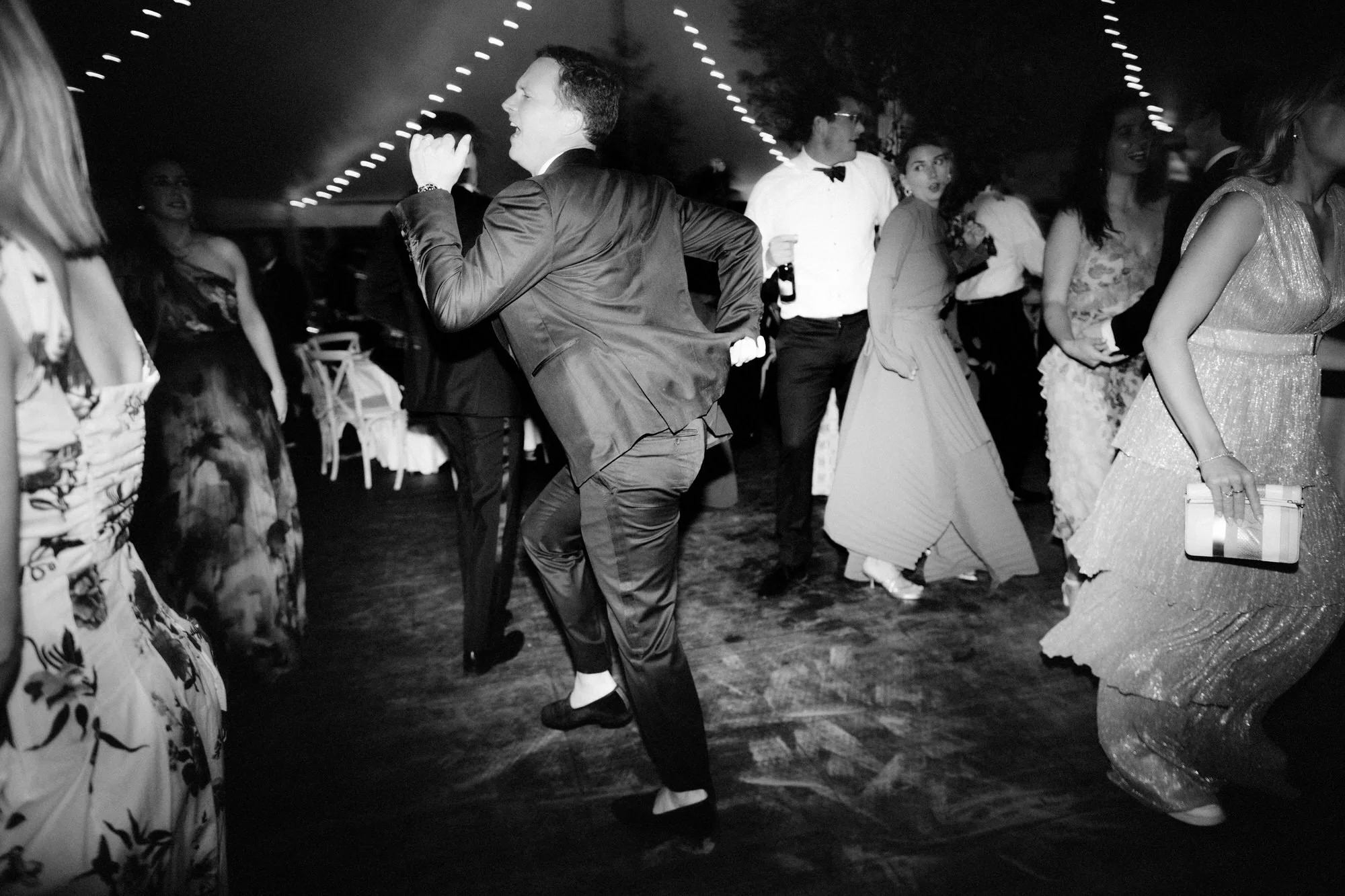 An energetic guest dances across the floor with motion-blur excitement at the Ausable Club Adirondacks wedding