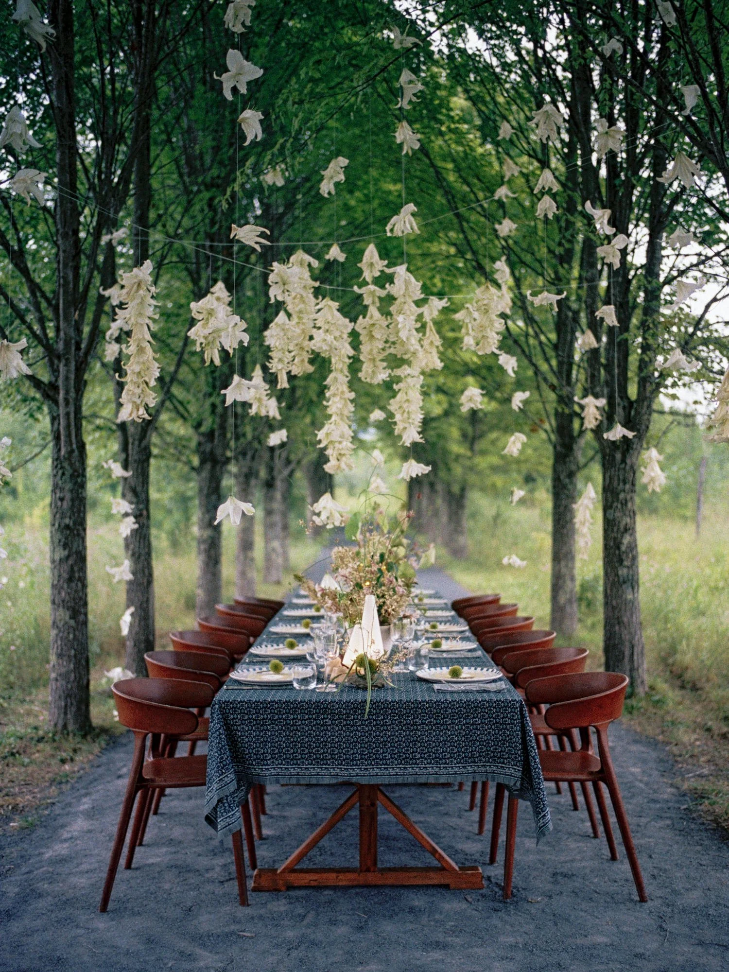 Outdoor reception dinner table with hanging floral décor at Wildflower Farms in Upstate New York