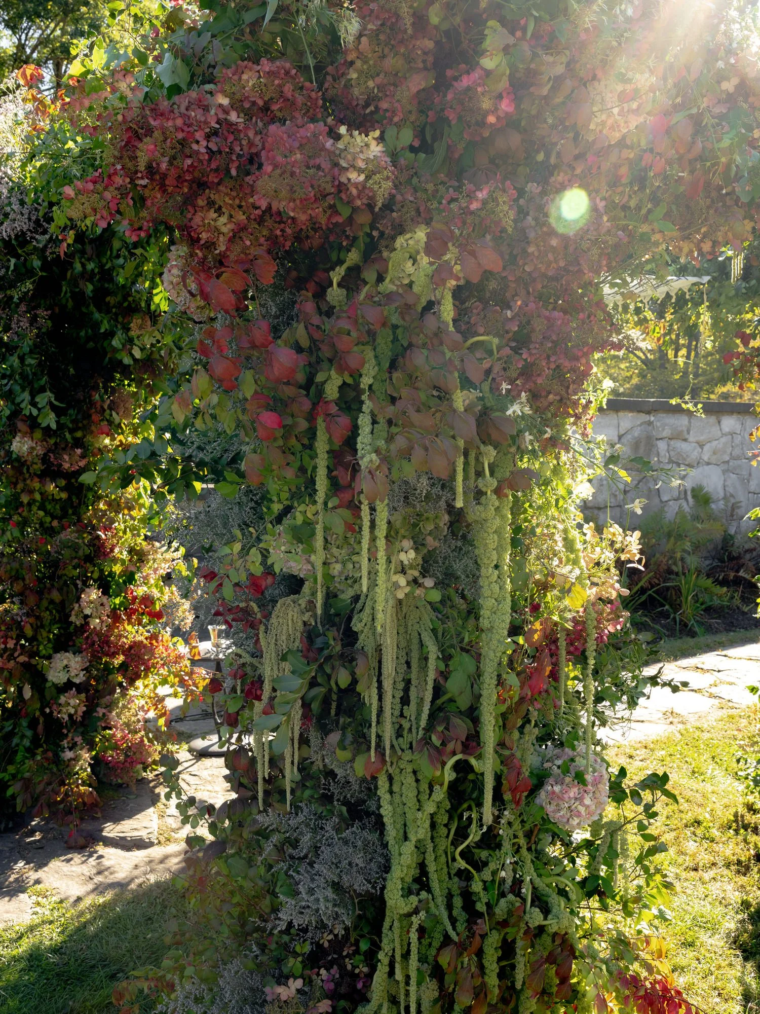 Close-up of the floral arch drenched in warm afternoon light at Troutbeck in Amenia, photographed by Jenny Fu.