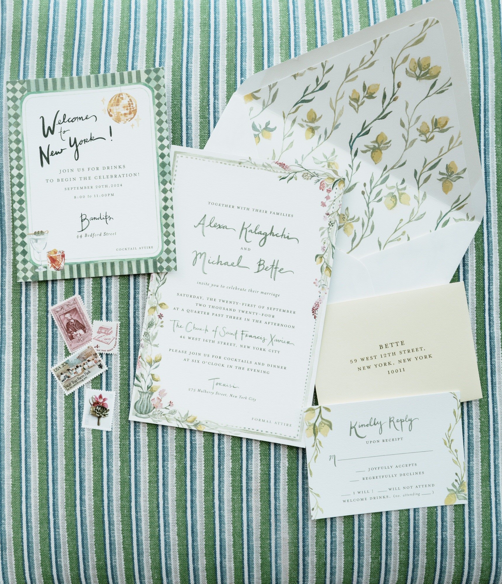 Wedding invitation suite and welcome cards arranged on green-striped fabric at Crosby Street Hotel in Soho, photographed by Jenny Fu.