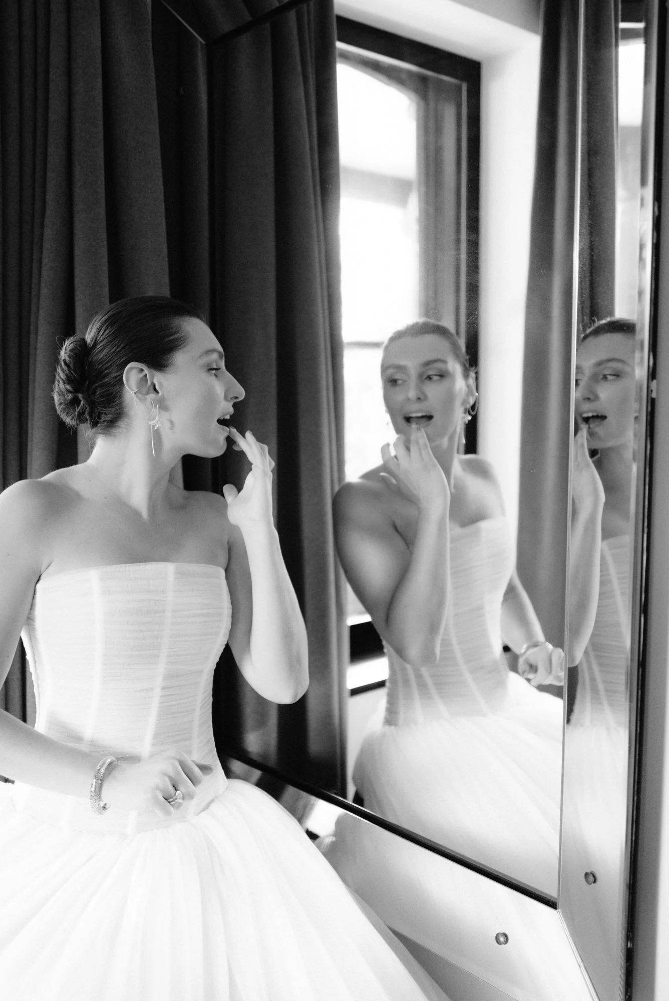 Bride applying lipstick in the mirror in a quiet black and white moment before the ceremony at Valley Rock Inn in Sloatsburg, photographed by Jenny Fu.