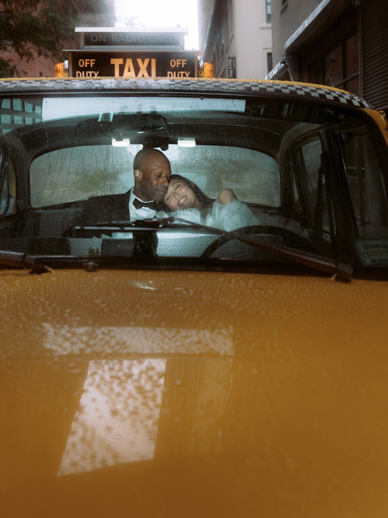 mp44-couple-cuddling-in-vintage-yellow-taxi-on-rainy-day-brooklyn-jenny-fu.jpg