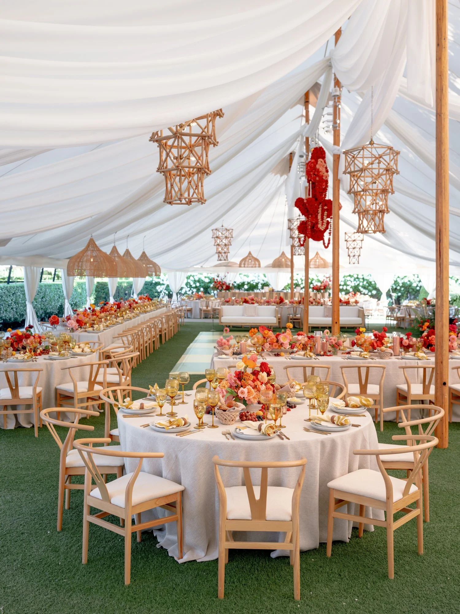 Elegant tented reception with flowing white drapery, rattan chandeliers, and colorful floral tables at Valley Rock Inn in Sloatsburg, photographed by Jenny Fu.