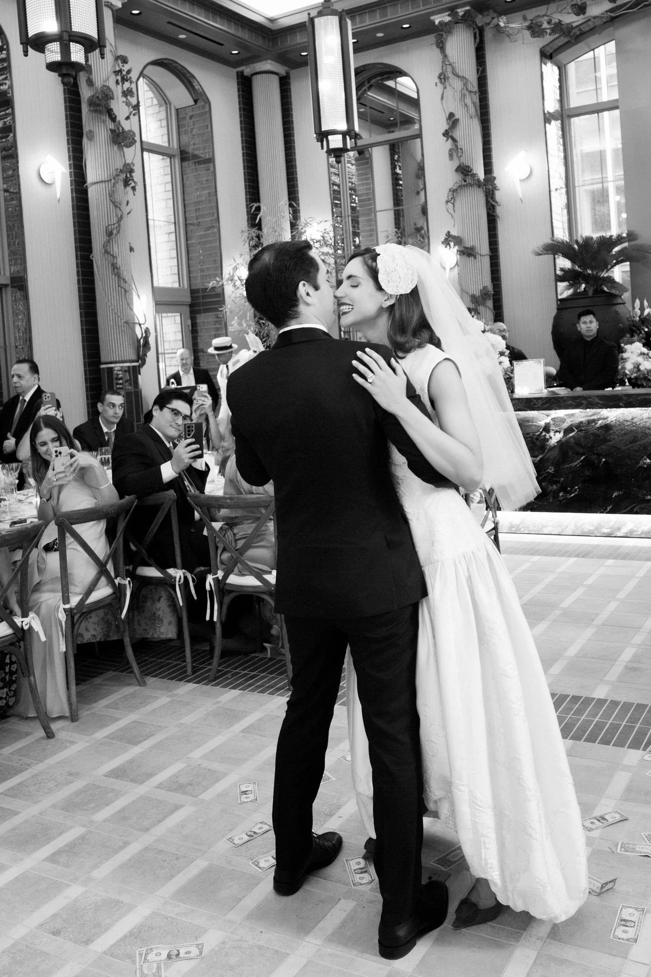 Black and white photo of the bride and groom sharing a dance as guests watch at the Waldorf Astoria New York, photographed by Jenny Fu.