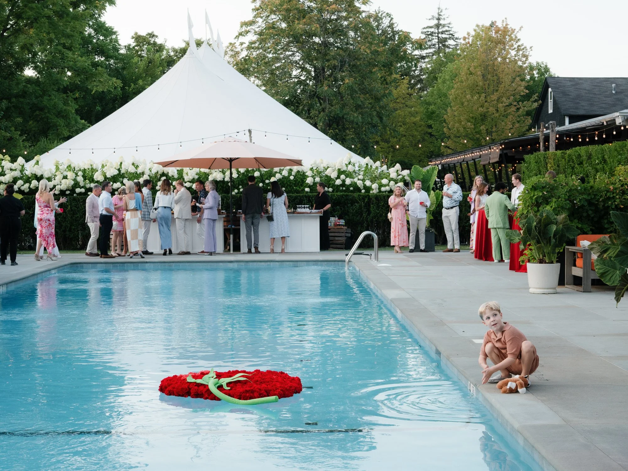 Guests gathered poolside near the tent during cocktail hour at Valley Rock Inn in Sloatsburg, photographed by Jenny Fu.