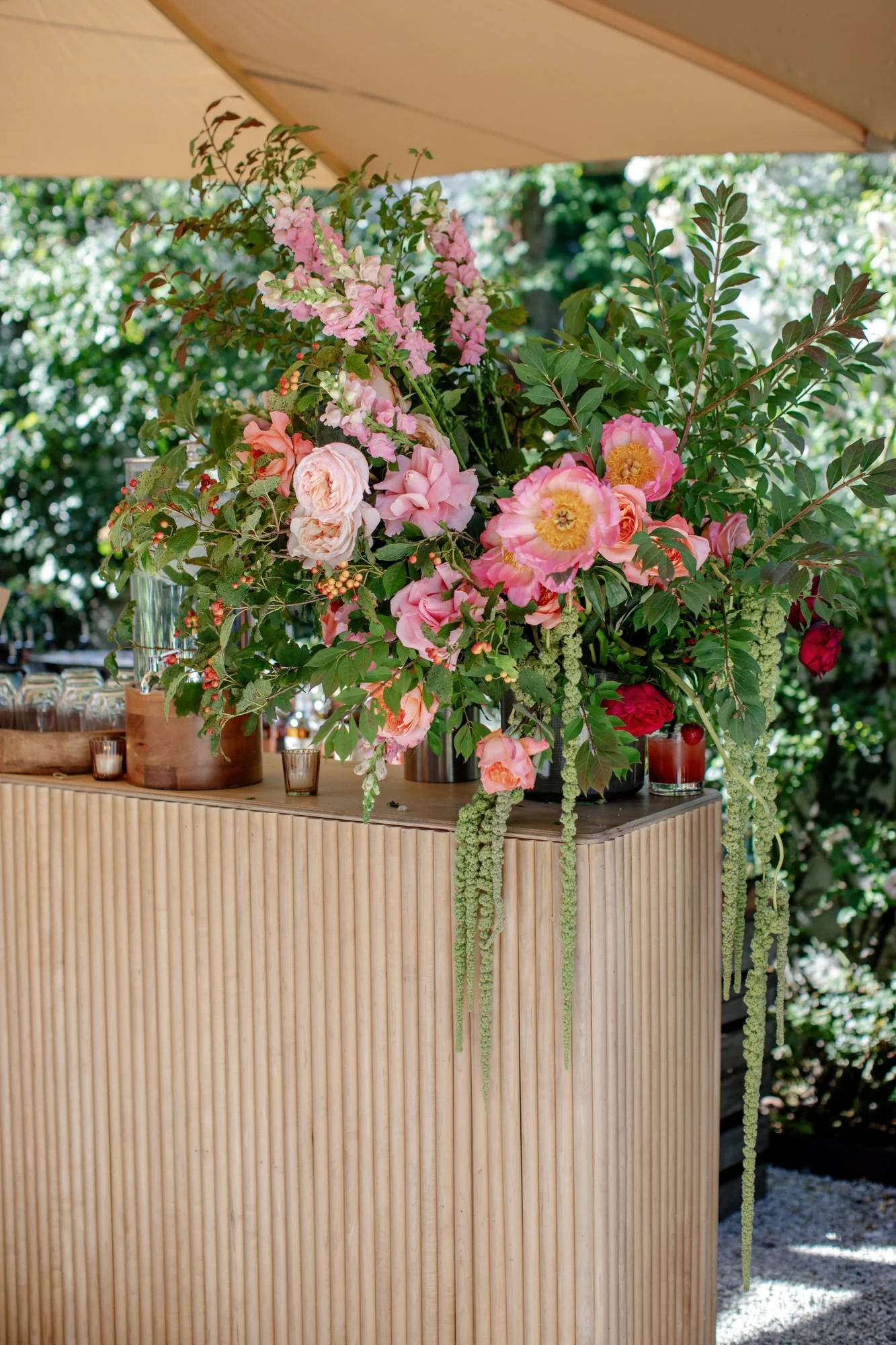 Lush bar arrangement of pink and coral blooms with trailing greenery at Valley Rock Inn in Sloatsburg, photographed by Jenny Fu.