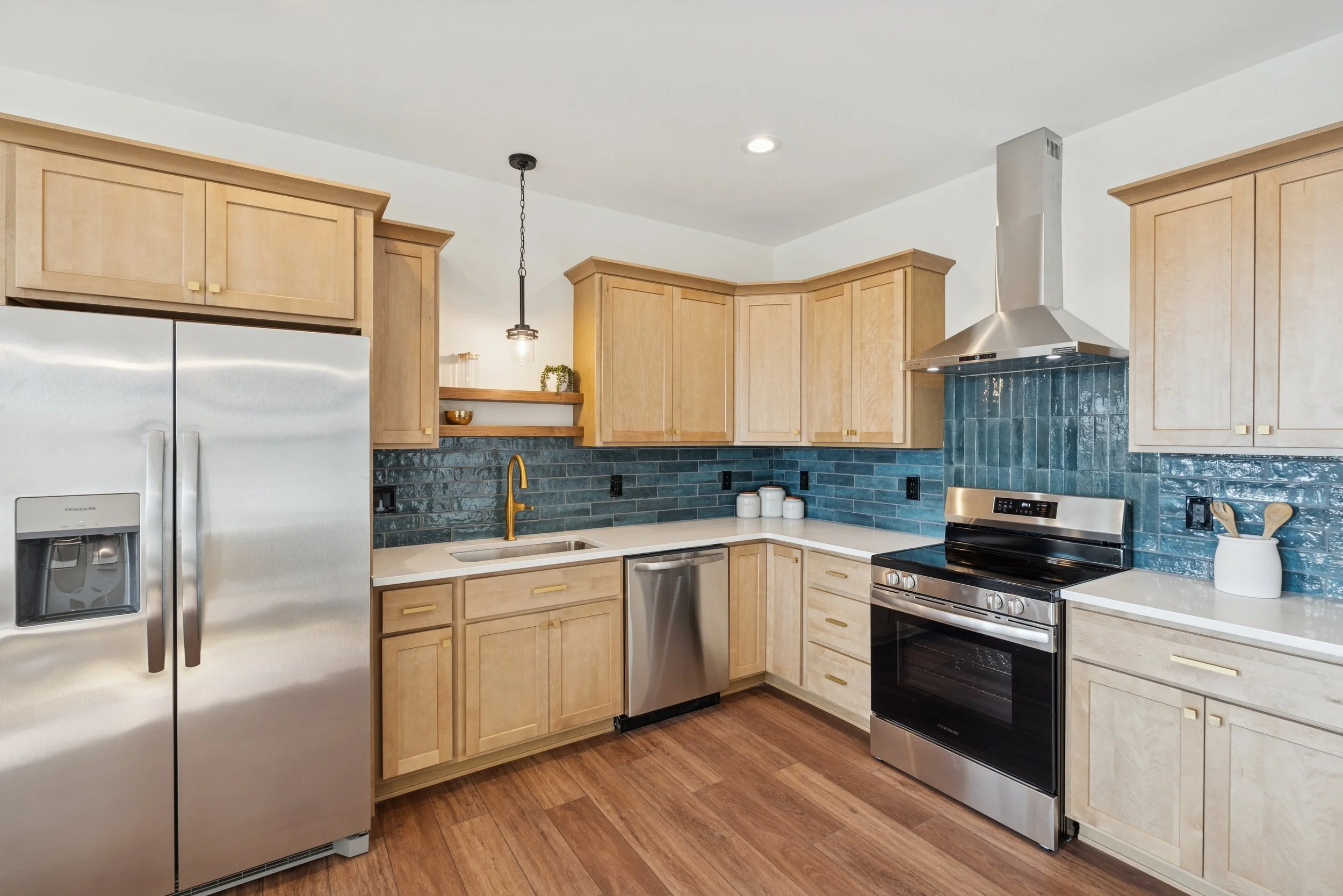 Ranch condo in howell michigan with custom blue tile, wood cabinets, brass hardware, and dark wood floors. shwerwin williams alabaster paint