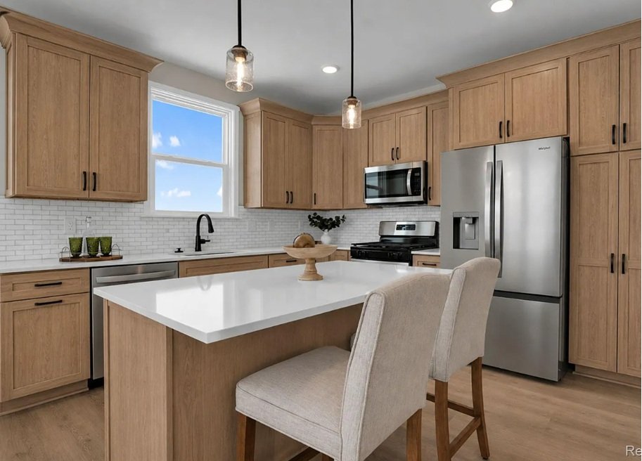 Stylish ranch condo in howell mi, with green grass, gray stone, gray siding, garage, sidewalk