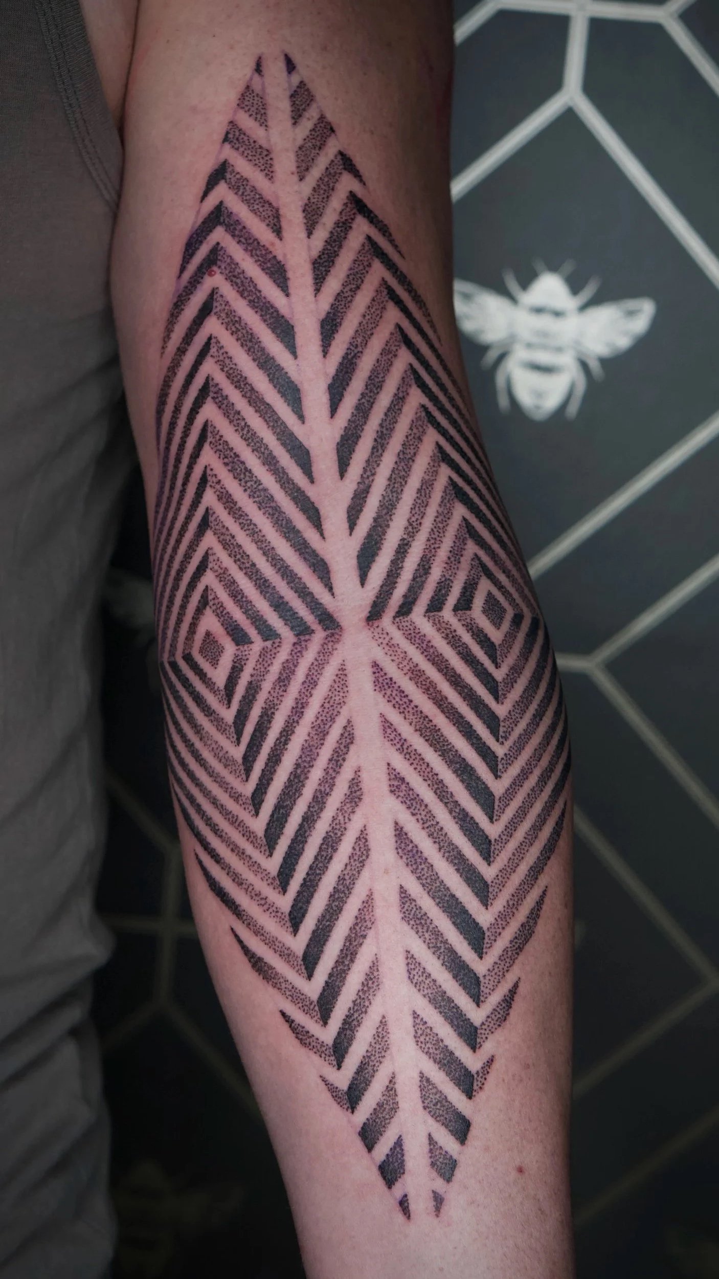 geometric dot work tattoo on inner elbow