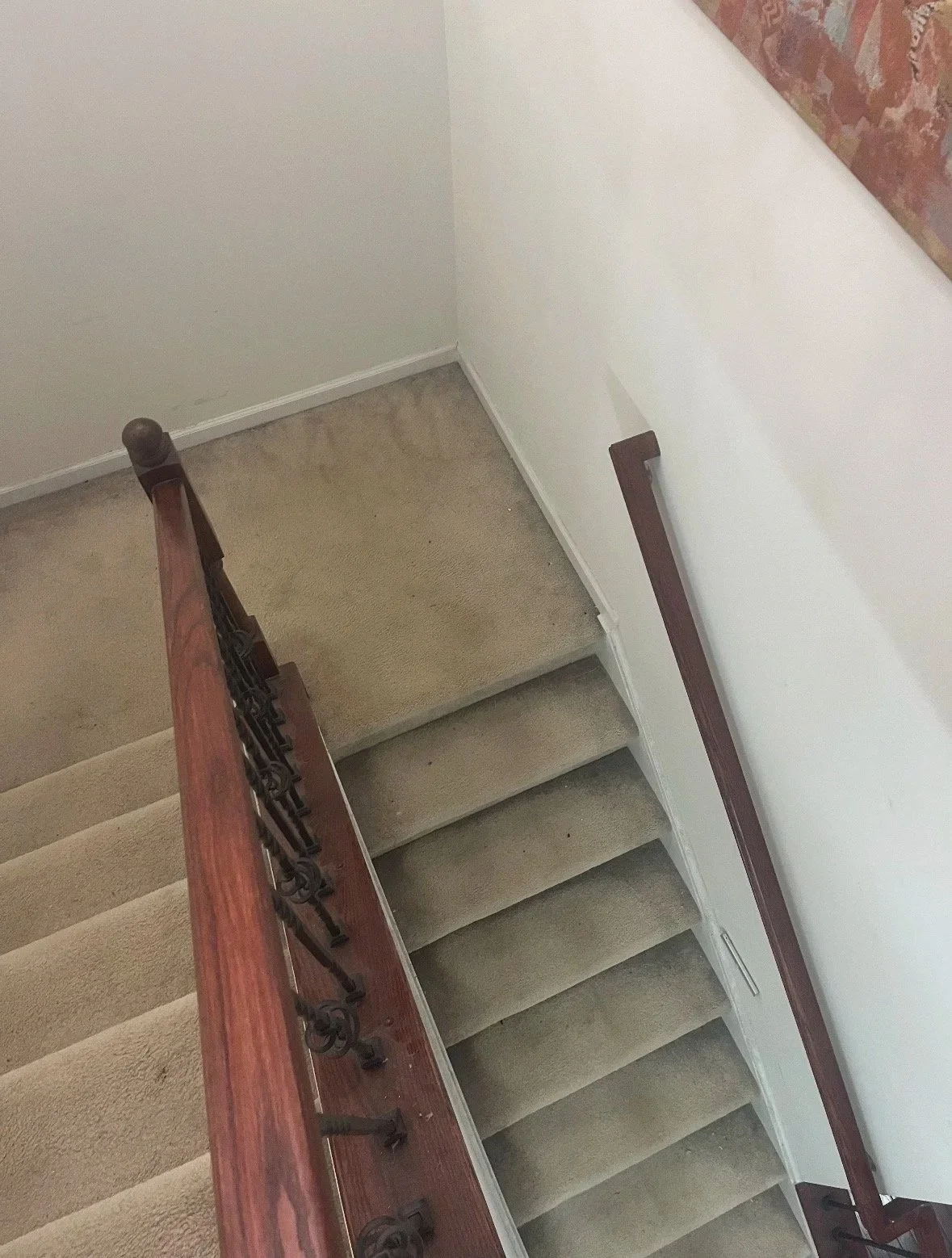 DMV DC, Maryland, Virginia flooring and carpet home repair, Top-down view of a carpeted staircase with a wooden handrail and white walls.