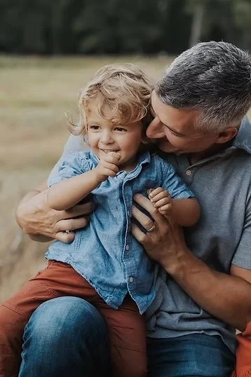 Tosti Design founder and craftsman Casey Tosti with his son on his lap.