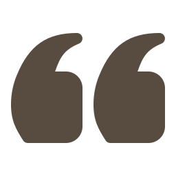 Close-up of large, stylized quotation marks in dark gray color.