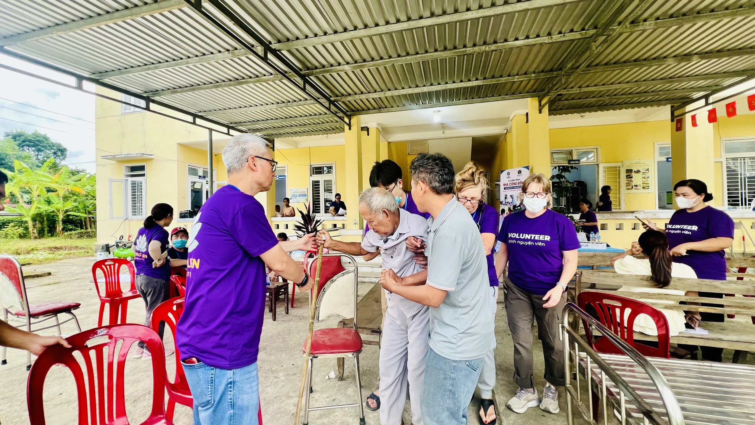 Hong Lien Foundation volunteers helping an elderly man at the mobile medical clinic