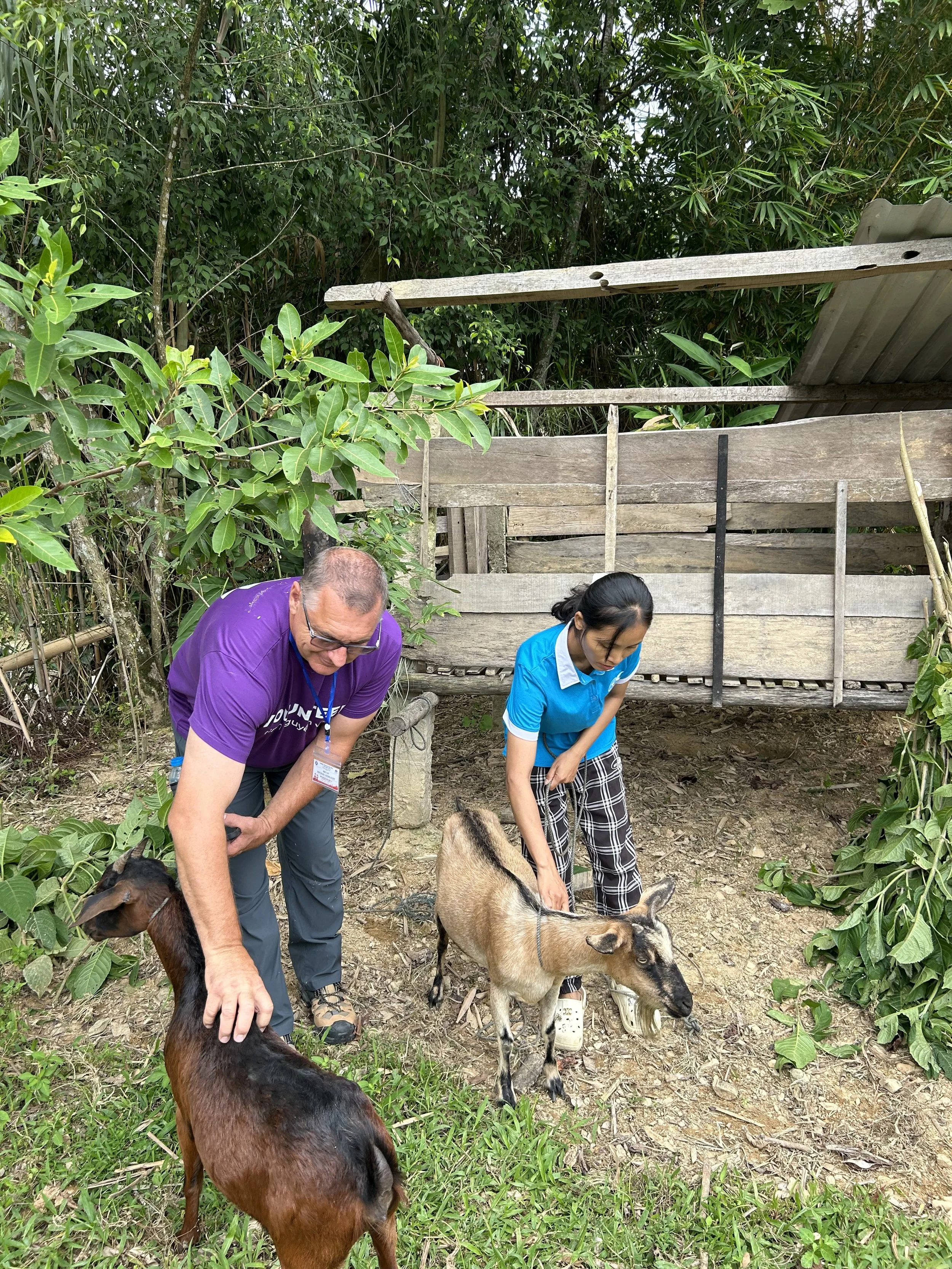 From Pilot to Possibility. Volunteer helping a farmer with the animal husbandry program.