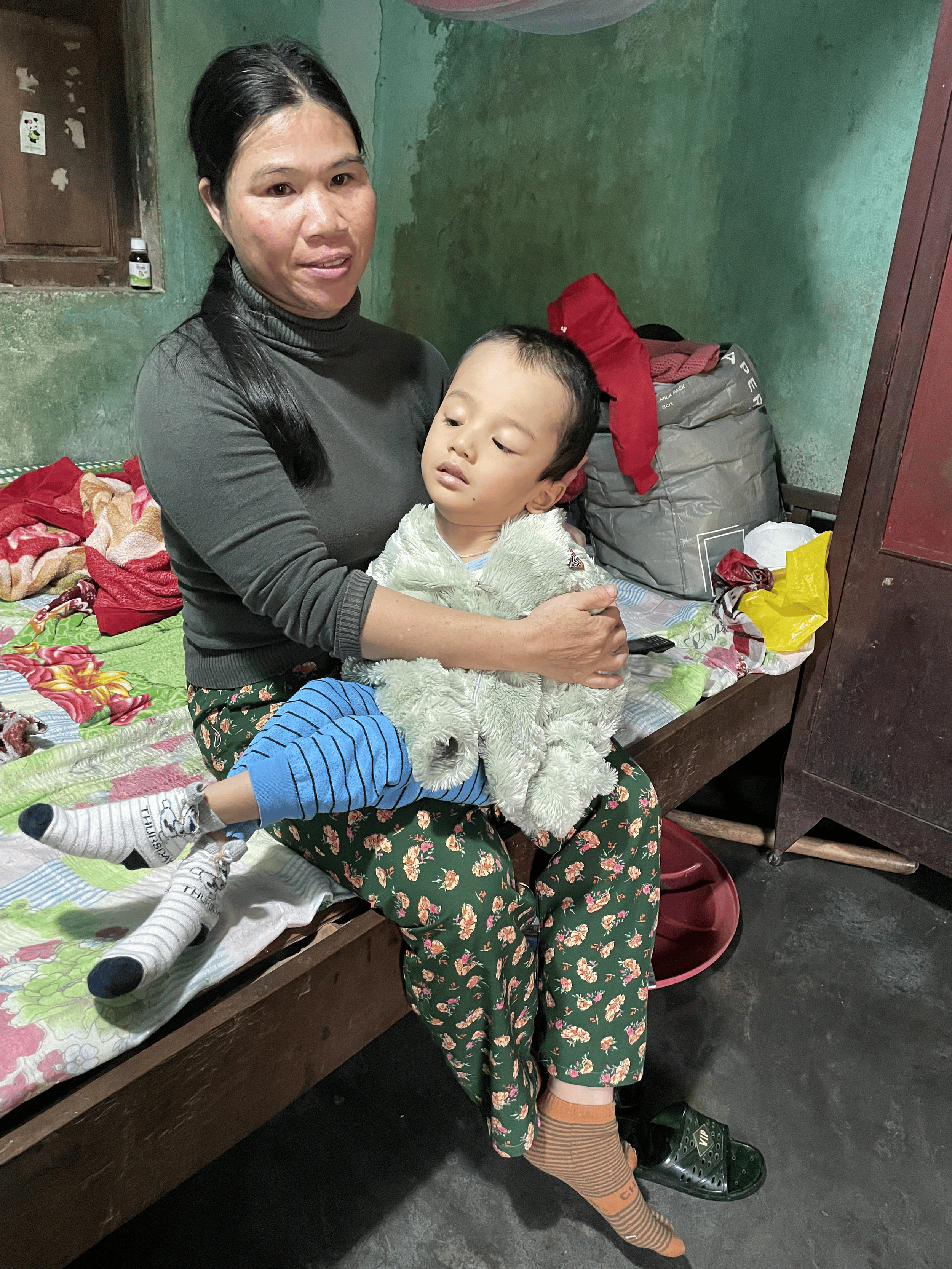 Tran Dang Duong held by his mother