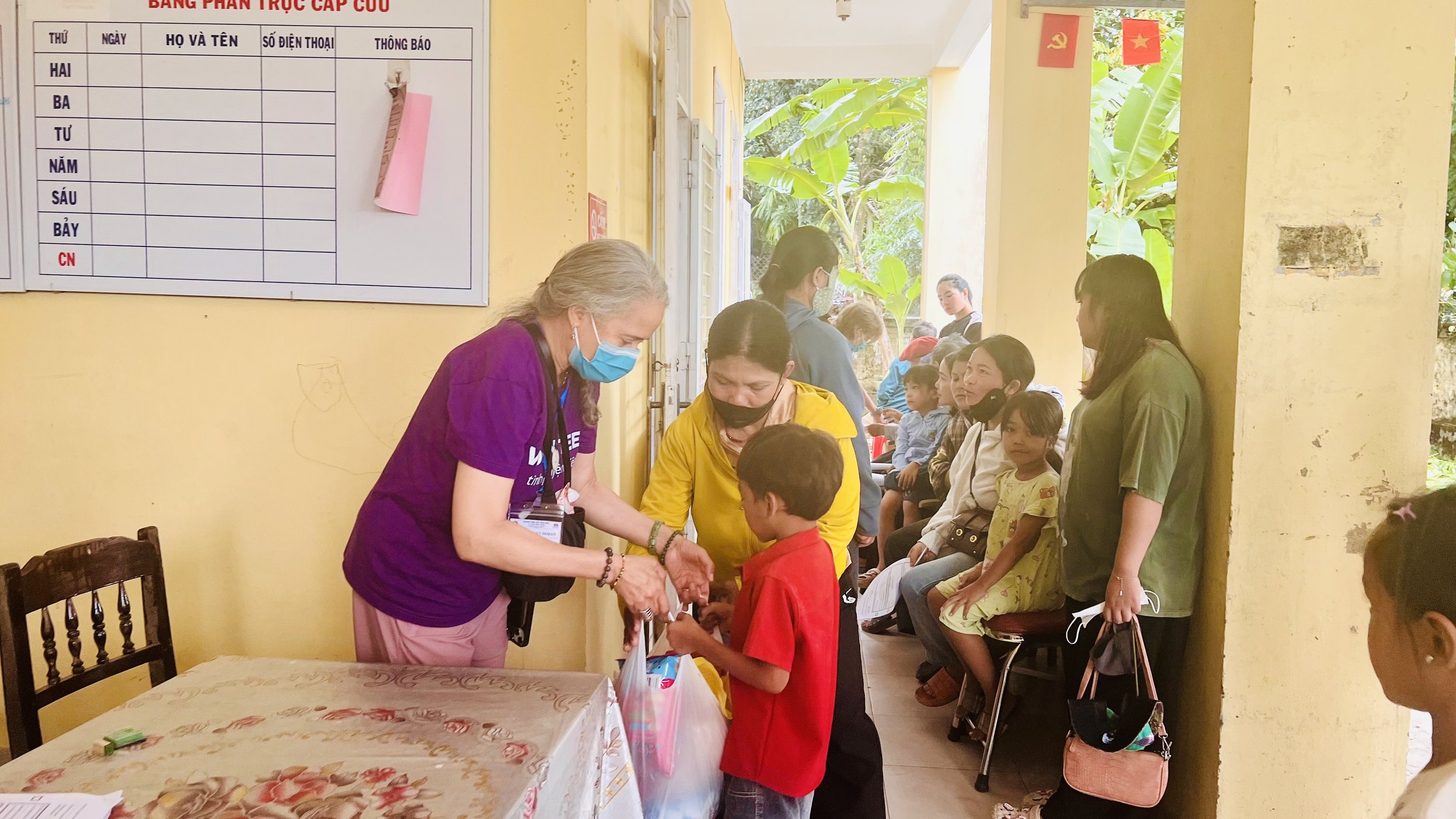 A volunteer distributing bags of food to local community.