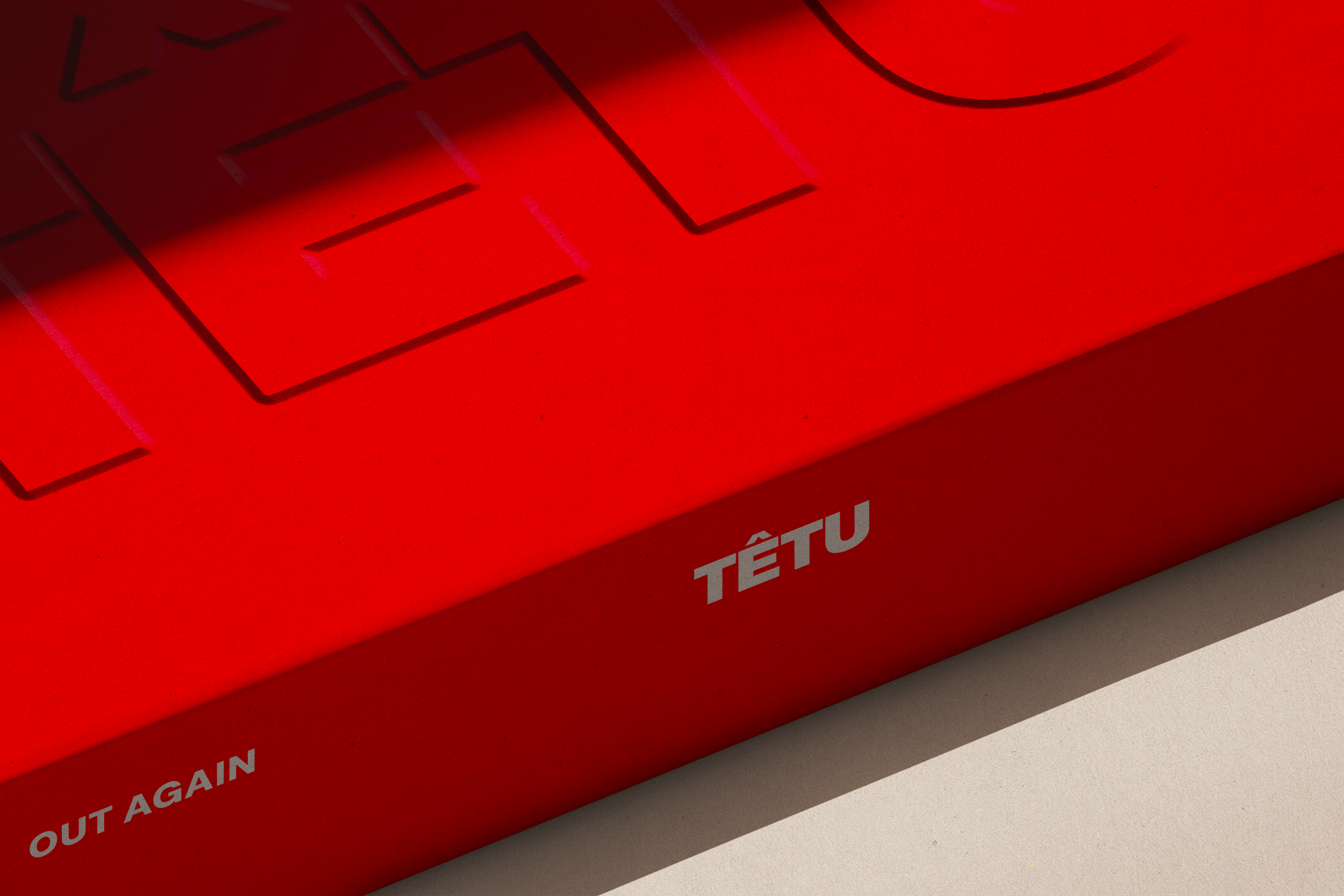 Jeu de société TETU en boîte rouge avec textes visibles, posé sur une surface blanche.
