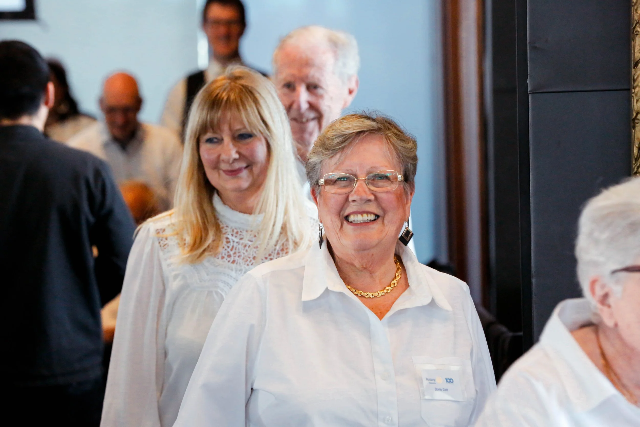 Adelaide City Singers choir at a performance in white shirts, smiling at the camera
