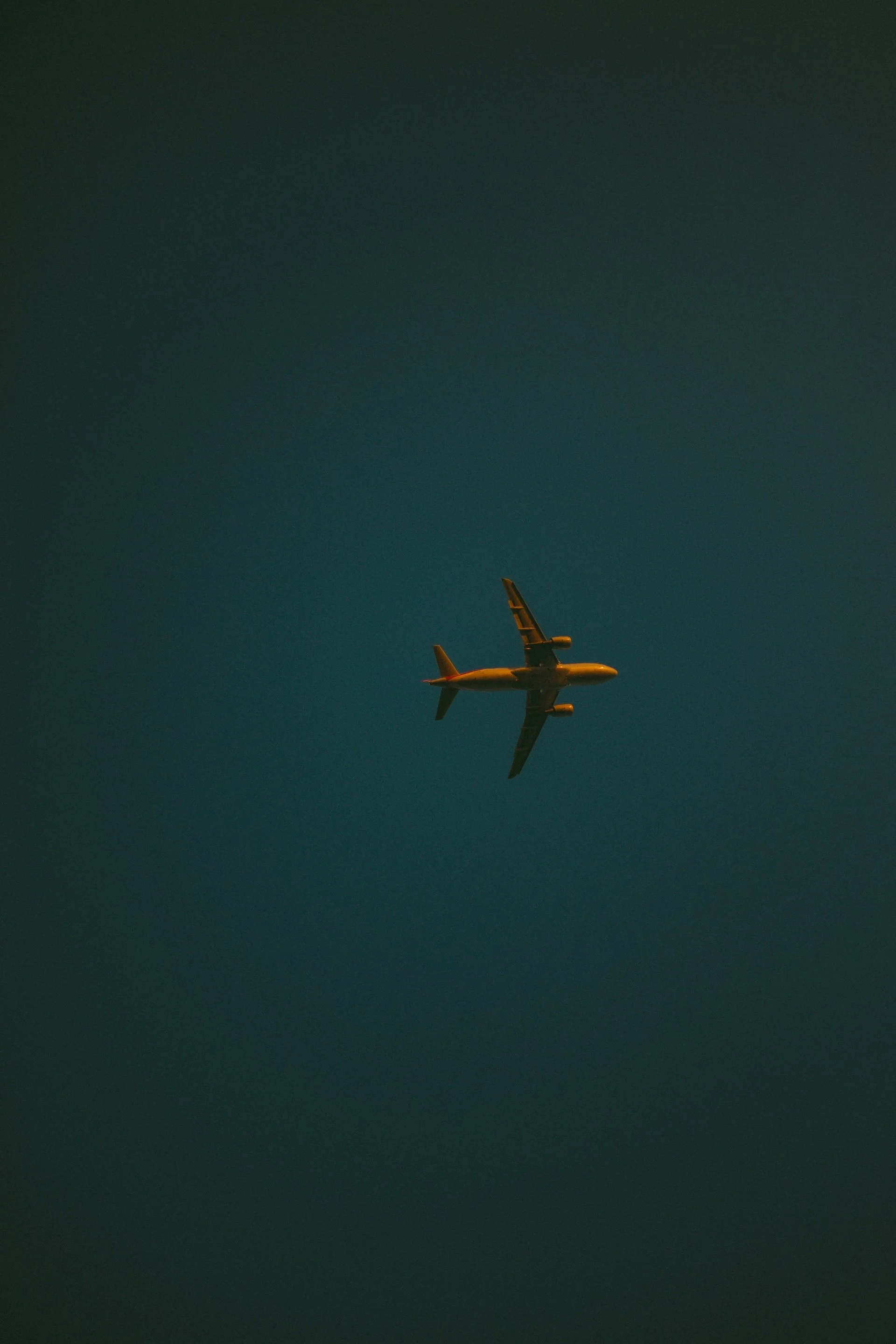 Airplane flying at night against a dark sky.