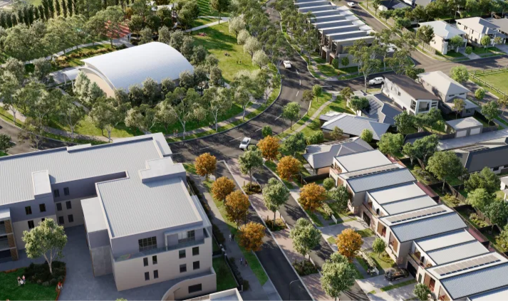 Aerial view of a residential neighborhood with modern houses, tree-lined streets, and a park with a covered gathering area.