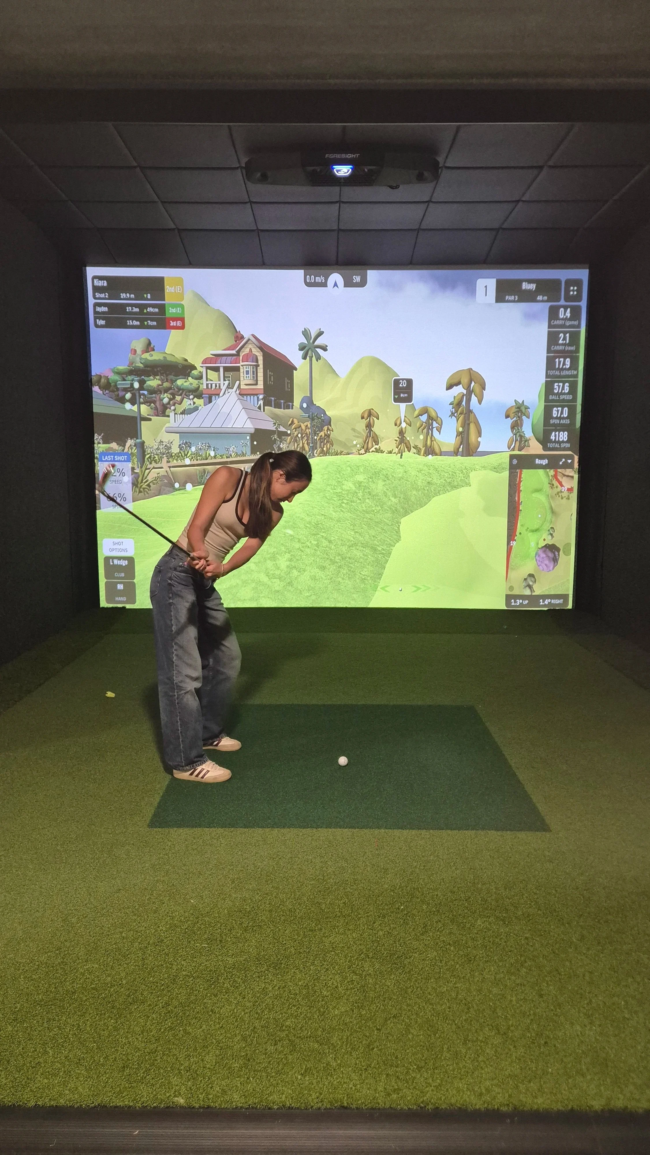 Girl plays indoor golf on the kids Bluey course at Urban Fairway in Auckland