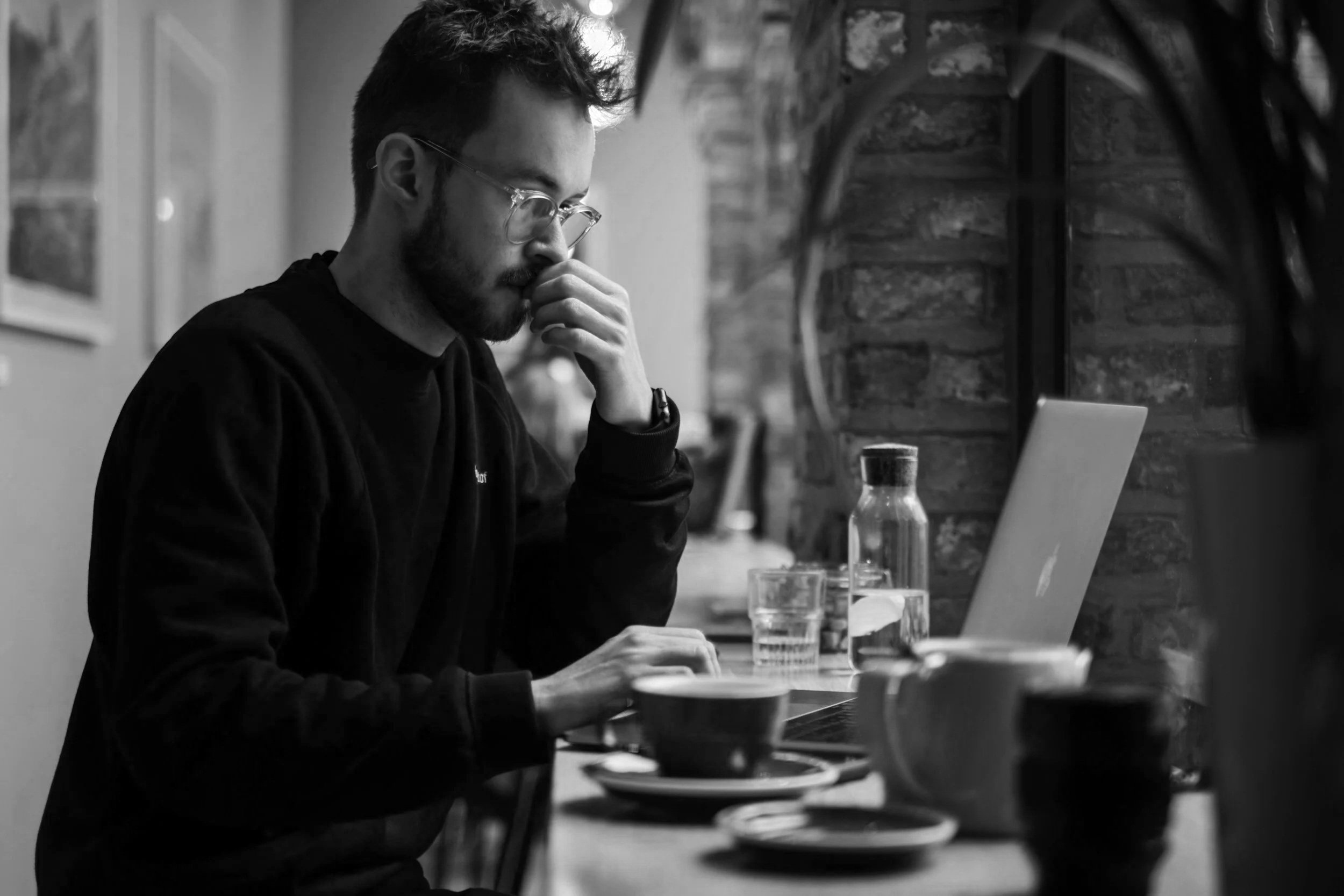man sitting in front of a laptop thinking