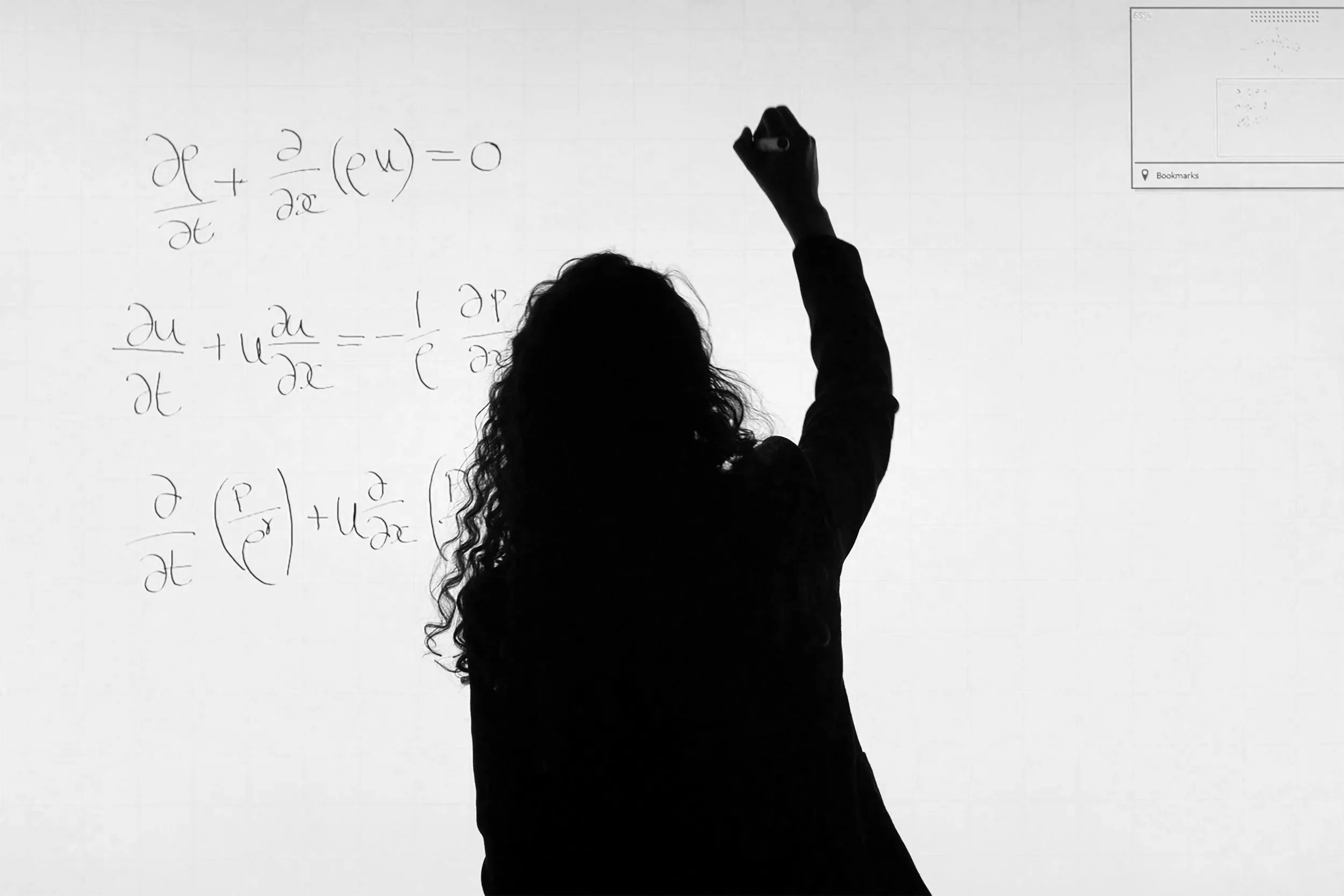 a woman writing equations on a white board