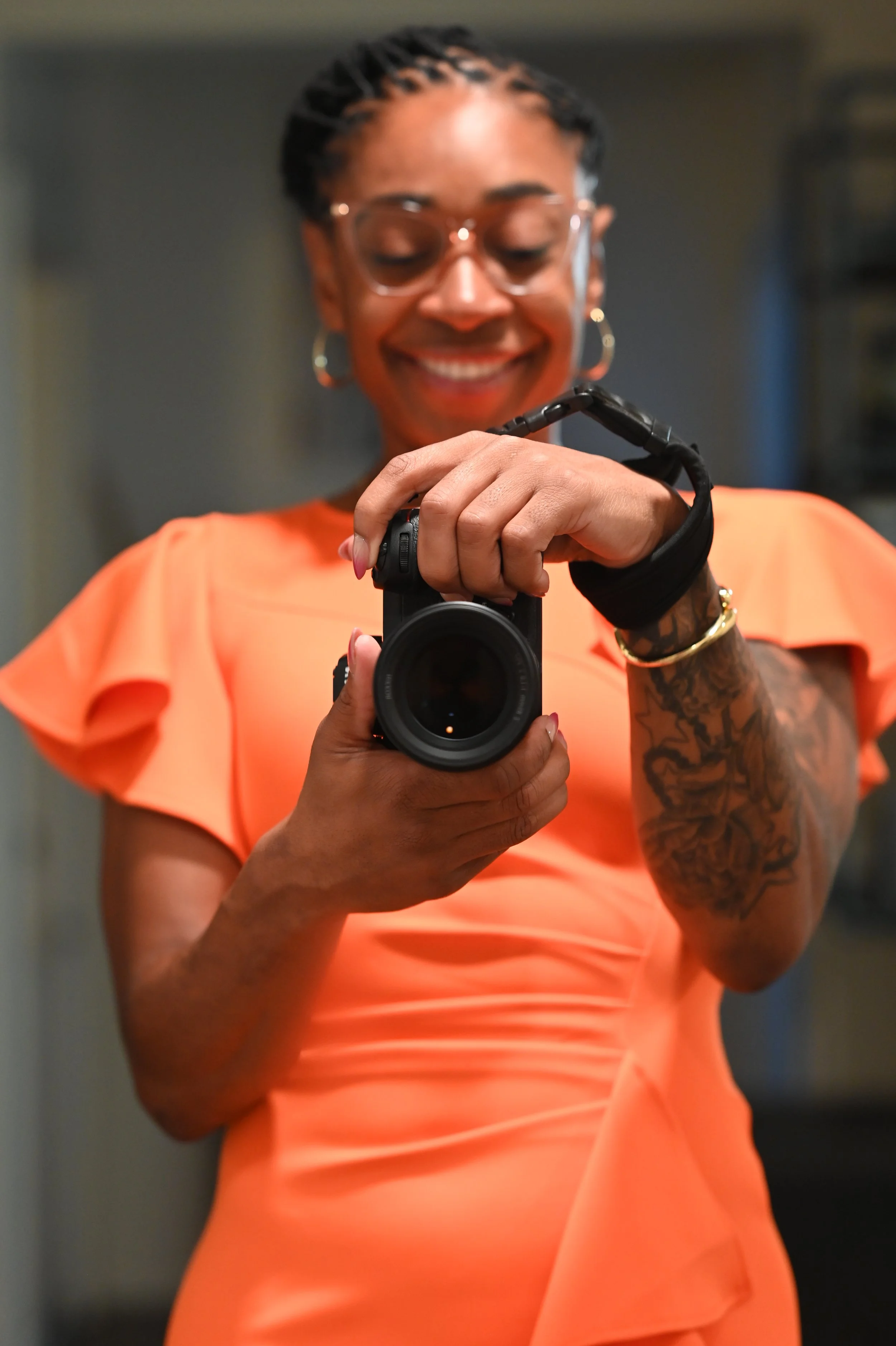 Rashida Saunders holding a camera and smiling while preparing to take a photograph.