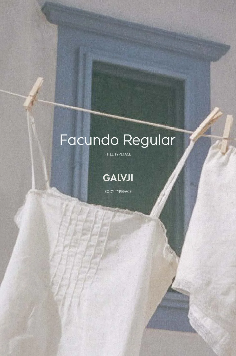 Close-up of a window with laundry hanging on a clothesline in front of it, featuring a white textured cloth and other fabric pieces.