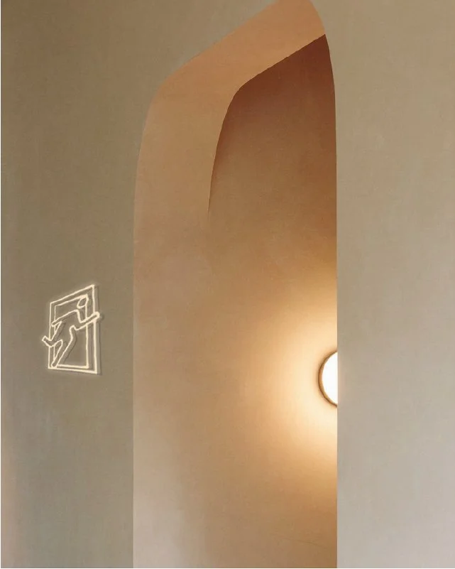 Interior ceiling with an illuminated emergency exit sign and ceiling lights.