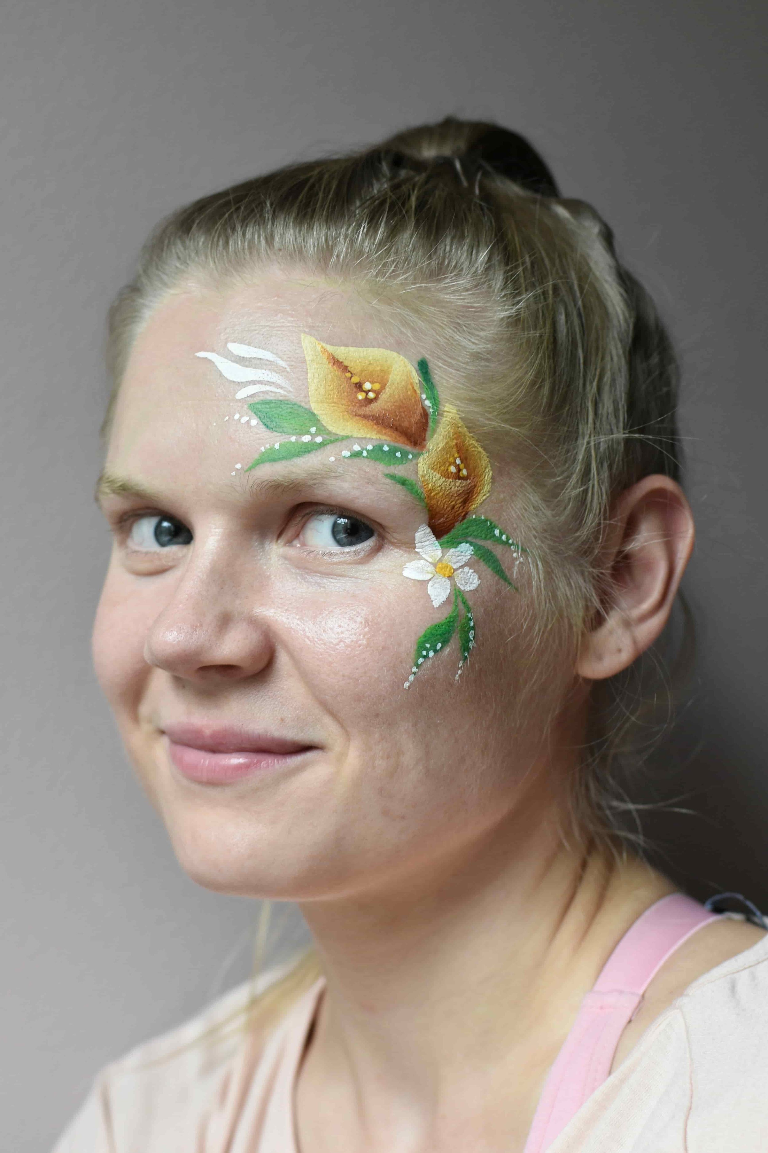 Aikuisten kasvomaalaus kukkia ohimolla